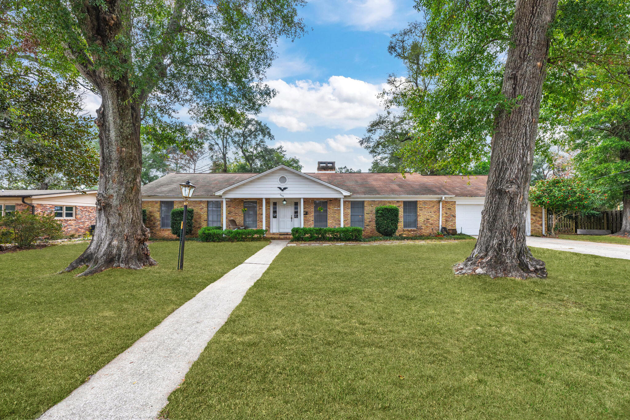 Located in the highly desirable Cordova Park neighborhood, this 4-bedroom, 2.5-bathroom home offers over 2,400 square feet of well-designed living space. With a prime location just minutes from shopping, dining, the airport, and Interstate 10, this home provides both convenience and comfort in the heart of Pensacola! A charming front porch leads into a spacious foyer, setting the tone for the warm and welcoming interior. The formal living room features a fireplace, built-in shelving, and windows overlooking the front yard bringing in lots of light. The formal dining room is right off the kitchen and boasts beautiful built-ins for dishes or knick knacks. The generously sized kitchen includes granite countertops, ample cabinet space including a pantry, as well as a breakfast nook, offering plenty of room for everyday living. Off the kitchen is a half bath, conveniently placed. The family room is a cozy retreat, featuring a brick fireplace with firewood storage, built-in shelving and a desk, wooden beams on the ceiling, and warm wood paneling that adds character. A door off the living area leads to the private backyard, where a large concrete patio and landscaping create a comfortable outdoor space for relaxing or entertaining. Down the hall, you'll find three linen closets for convenience and four spacious bedrooms, each with ceiling fans and ample closet space. Nestled between the bedrooms, there is a full bathroom equipped with a tub/shower combo and dual sink vanity. The primary suite is updated and includes a large standing shower and modern vanity. A separate laundry room offers additional storage with a pantry and counter space for folding. The two-car garage features a workshop area, providing extra storage or space for hobbies. Located in a quiet yet central neighborhood, this home offers a fantastic opportunity for those seeking comfort, convenience, and space, or for those looking to renovate in one of Pensacola's most established communities.
