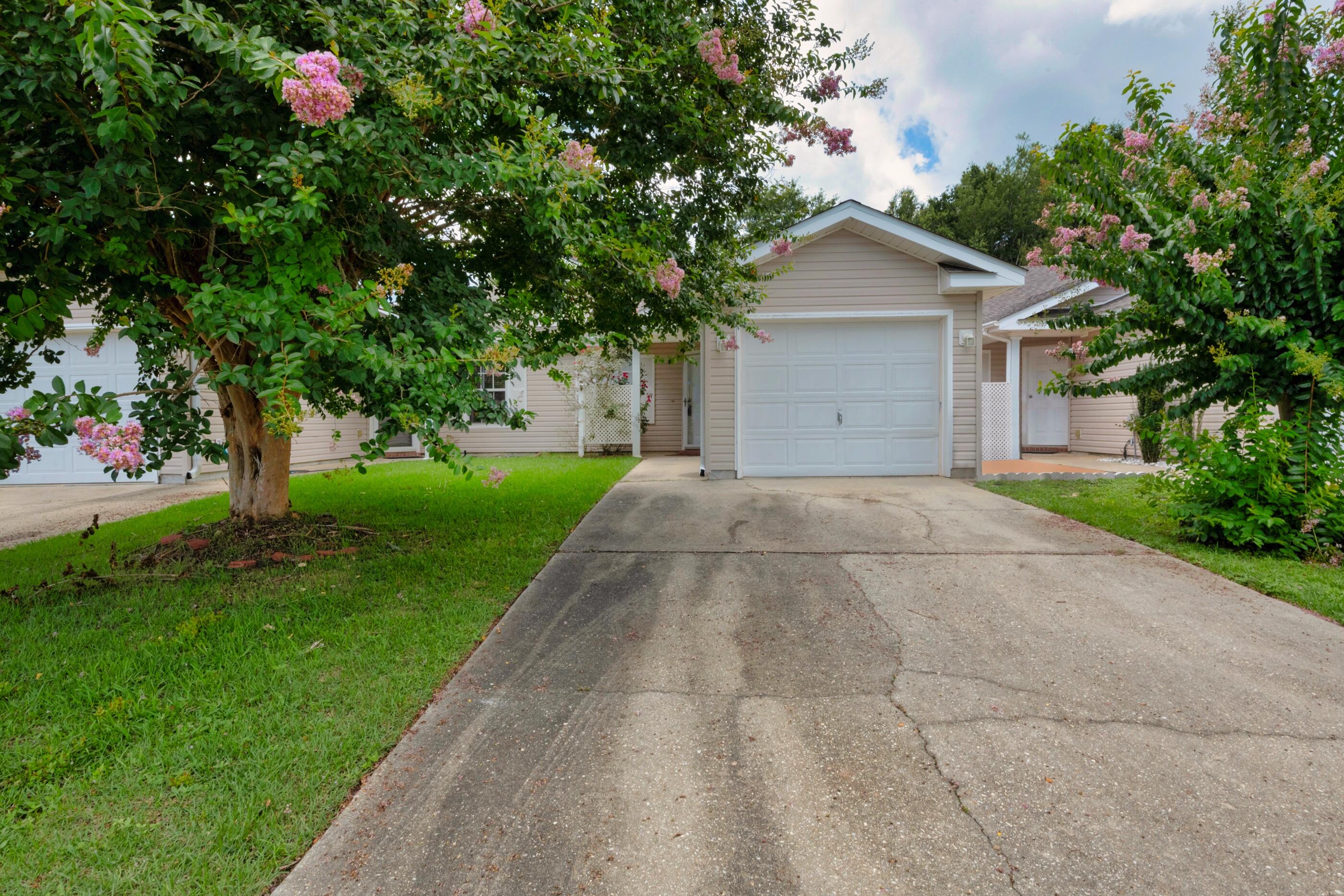 Charming villa with an intimate setting gives you every comfort of a small-town Florida feel while maintaining a low maintenance lifestyle. This well-kept attached unit features convenient vinyl siding, manicured grounds, and an attached one car garage. The outside of the home is flanked by picture-perfect white shutters while the entrance is accented by a vibrant rose bush encompassed by a white trellis. Through the storm door you will find a tiled foyer that leads you through to the spacious main living area that features an airy open plan living space and vaulted ceiling. At the front of home, you will also find convenient access to the garage and a large separate laundry room. The simplistic floorplan is characterized by clean lines and a monochromatic palette that emphasizes views