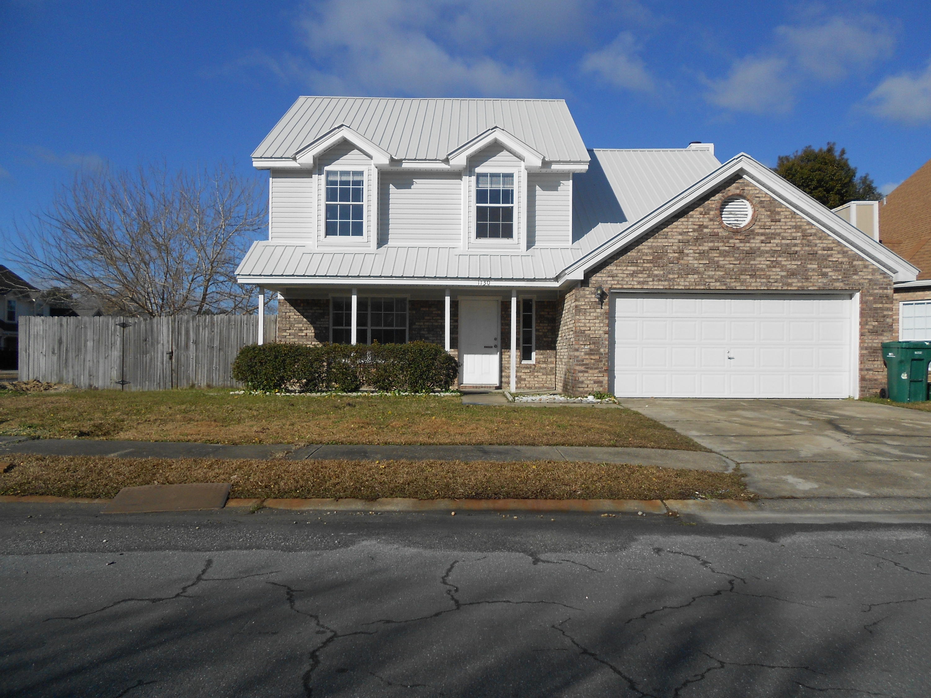 Downstairs has tile throughout. The stairs and all of upstairs have carpet. Blinds in all windows and a refrigerator make this house completely ready for move-in. Living room with fireplace and Family room are downstairs. Back yard is privacy fenced. Corner lot with easy access to Hurlburt and Eglin.