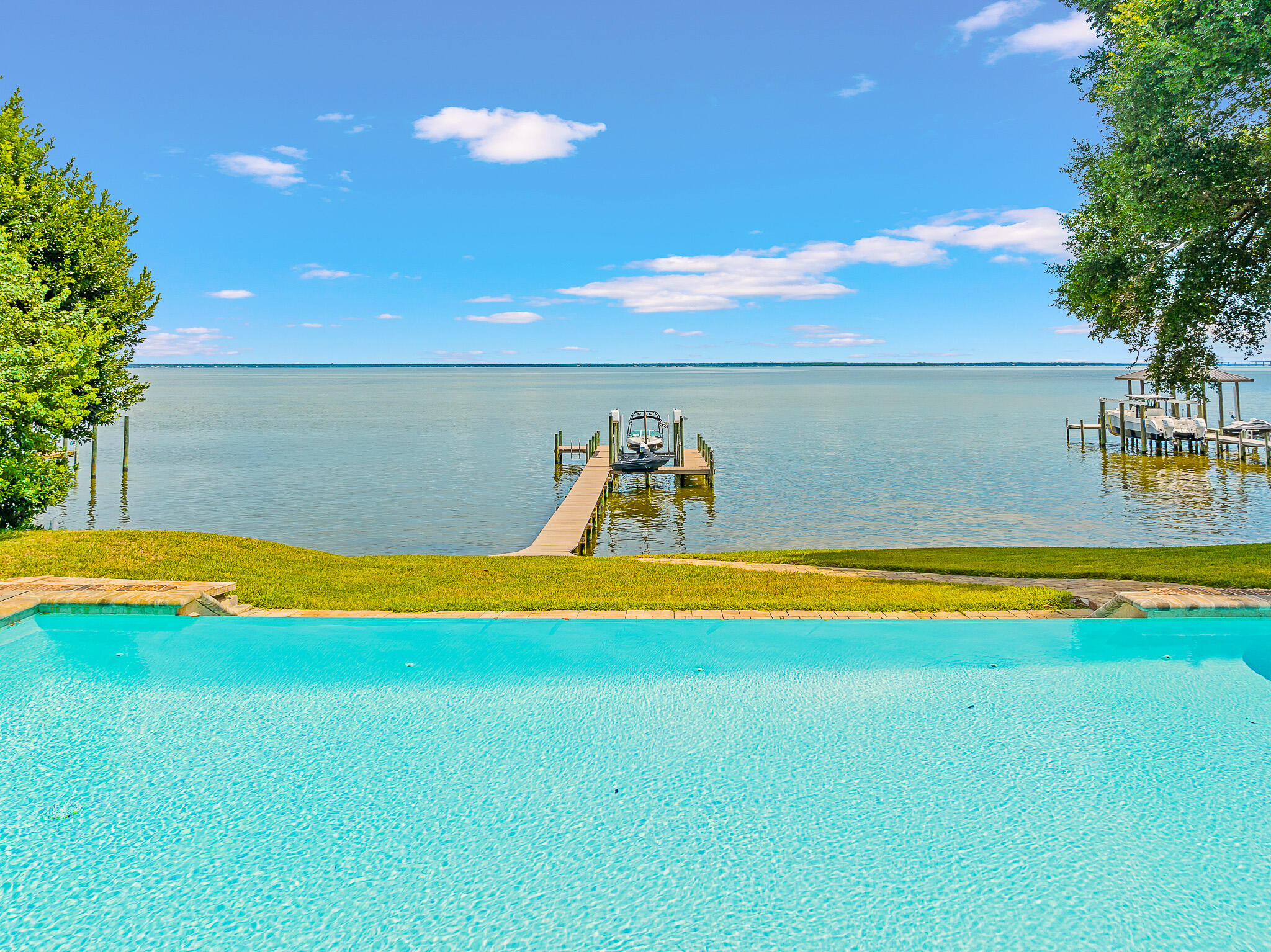 100 feet of Bay frontage at one of the highest points in Destin with this 2013 builthome! This spacious, meticulously maintained single-level brick home on an estate-sized lotprovides the ultimate setting to take in the bay views and breezes, complete with a dock, boatlift and jet ski lift. Thoughtful outdoor living space includes a covered patio and wide sundecksurrounding the pool. Enter the long driveway under a canopy of shady oak and magnolia treesto this four bedroom, three and a half bathroom custom home, built less than ten years ago.