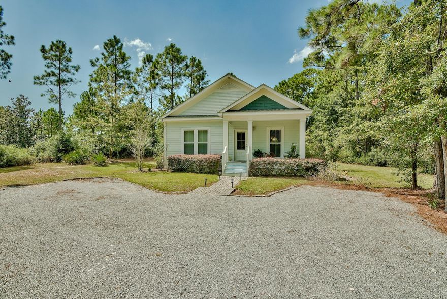 Charming 2-bedroom, 2-bath one level home in 30A nestled on plentiful acreage with commercial potential. This property has a lot to offer! The location and privacy of this home cannot be beat. Located just south of US Hwy 98 on 393, this home sits on 1.94 acres with beautiful, lush surroundings! 0.4 acres was cleared for the home itself and a gravel driveway that offers two parking spaces. This lovely home welcomes you with a chic paver walkway and freshly painted covered porch. Upon entering the home you are greeted by raised ceilings with beautiful crown molding, recessed lighting and hardwood floors throughout the main living areas. Desirable Florida cottage feel with the metal roof and hardiboard exterior. Enjoy the serenity of the surrounding woodlands from your front and back porch.
