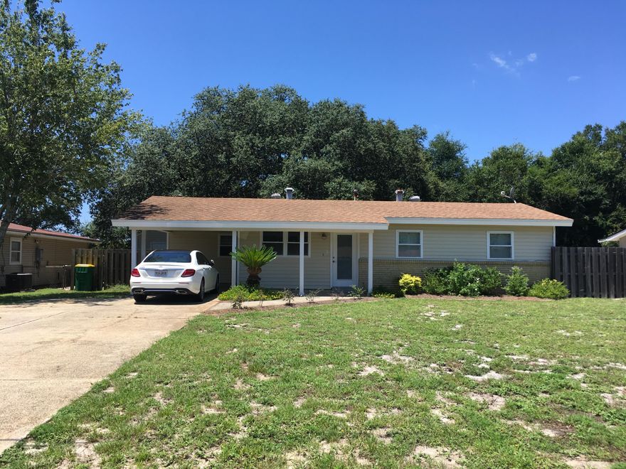 Newly cleaned up and all exterior doors and columns re-painted. Remodeled and updated house right off Hwy 98, near Hurlburt entrance!! This house shows off with the large open living and kitchen area. There are three bedrooms, one bath and a walk-in laundry room. Laminate wood flooring throughout with tile in bathroom and kitchen. The kitchen boasts tile countertops with ample cabinet space. Each bedroom has a 2x6 closet. A large, wood fenced backyard has beautiful oaks and a wood patio. There is also a detached slab on grade storage shed in the backyard. Carport with extended side driveway. Seller will update shower with new tile with full price offer.