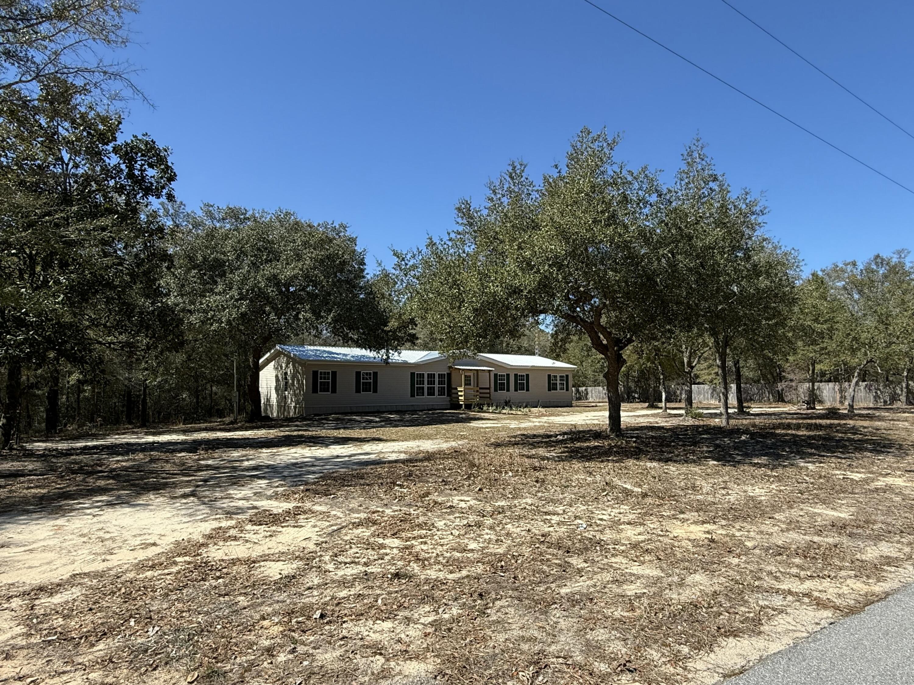 This beautifully remodeled manufactured home showcases a range of impressive upgrades that have transformed it into a stylish and comfortable living space. Freshly painted interior walls and new flooring throughout. The kitchen features new countertops and all stainless steel appliances. New deck, perfect for sitting outside and enjoying the outdoors. This addition extends the living space and provides an ideal area for relaxation or entertaining along with landscaping. Easily accessible to the surrounding highways, Shoal River Ranch, beaches, and local area attractions. Property is zoned for agricultural use.