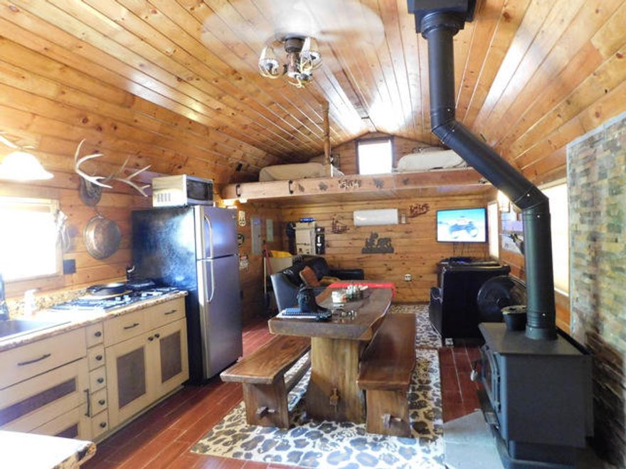 Owner financing available! 100,000 down 10 Yr. amortization, 6% interest , 5 year balloon. Beautiful cabin in the woods that sits on 52.08 acres of lush land with woodlands, pastures, hunting plots, trails, deer stands and blinds. It's an awesome getaway & retreat! A hunter and nature lover's paradise.The building/residence is off grade and is 40 x 14 with a 12 x 40 covered front porch and a nice back deck. Featuring tongue and groove interior wood finish and granite counter tops. The bathroom has a beautiful copper sink, granite top and custom natural stone floor and shower. Pure upscale country luxury. The cabin is powered by a 3.5K solar system with propane for the gas stove top and unlimited instant on Rheem hot water from the well that supplies water with only 15 ppm