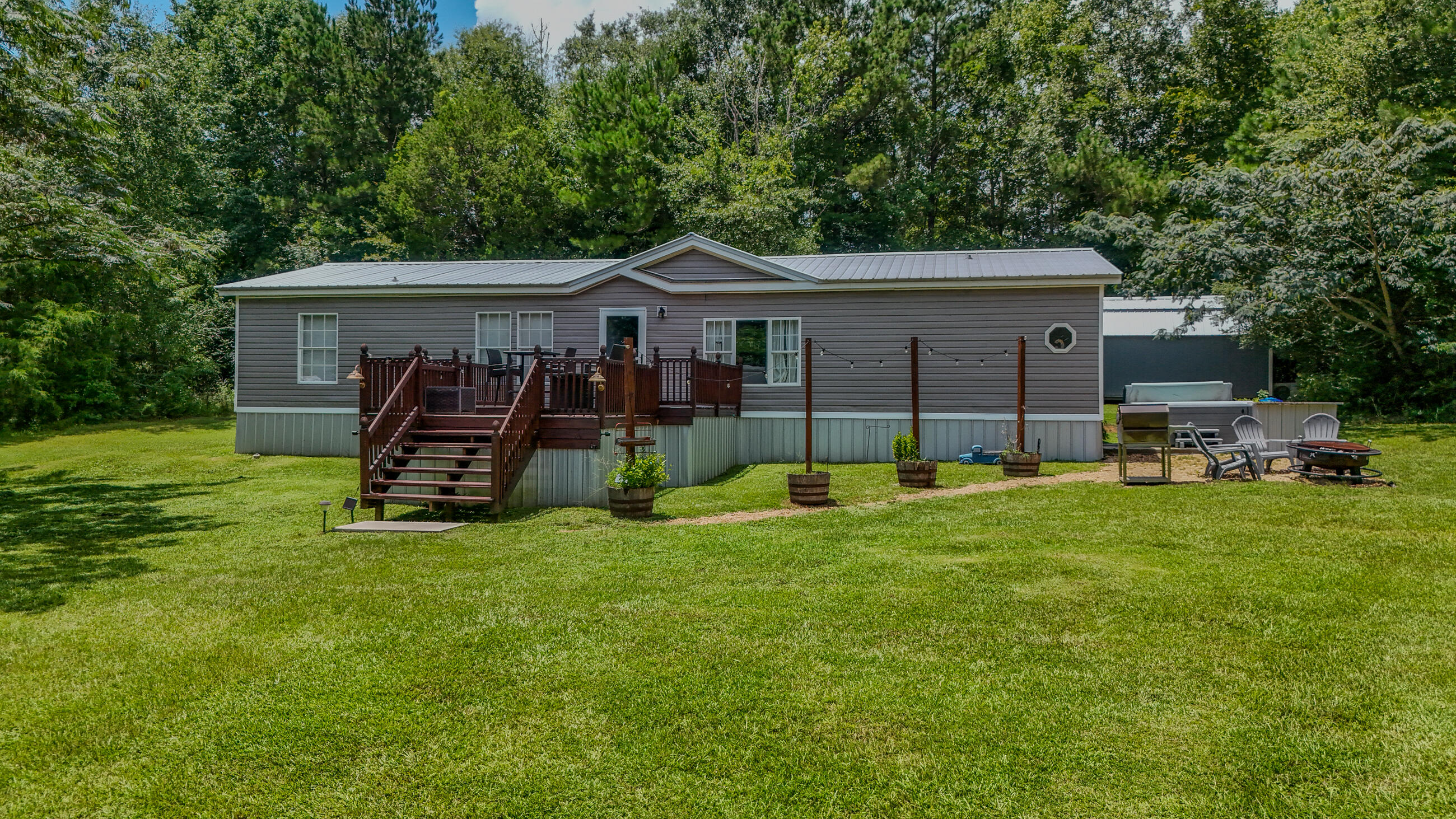 This impeccably maintained home sits just 8 minutes from Hwy 331 S. making it a great location for commuting to a multitude of places including the beaches of South Walton (45 minutes), Egin AFB (45 minutes) or Interstate10 (10 minutes). Upgrades to this 3 bedroom, 2 bath home include custom kitchen cabinets, one year old vinyl siding with Tyvek wrap underneath, and a 3 year old metal roof with water rubber waterproofing underneath. Outside you will find an inviting hot tub on concrete slab, a 32x40 pole barn with a 12x32 insulated bay with concrete flooring and a 12x24 double lofted build-rite building. Another gem on this property is a 12x32 tiny home, double lofted and completely renovated. Additional acreage available with MLS#982575 and/or MLS#982576