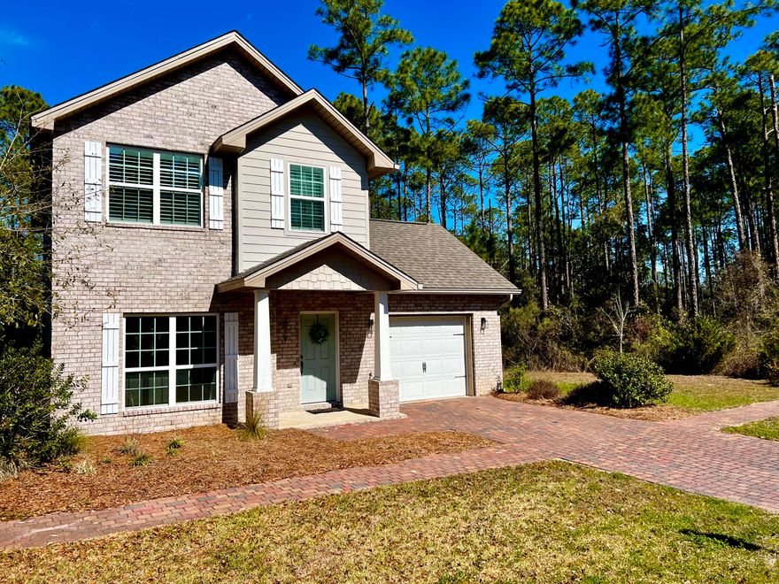 Enjoy nearby 30A beaches, shopping, dining and more, yet nestled back quietly toward the bay. Imagine being surrounded with wooded preserve to the north side of you, and green space to the east; such peaceful privacy this home offers. Brick exterior, 2 story, 3 bedroom, 2.5 bath has many upgraded designer features including: dark hardwood floors, quartz counter tops and a custom island. French doors take you out back to a lovely paver patio - perfect for outdoor entertaining. Extra details include interior plantation shutters, bronzed hardware, and exterior wooden shutters adorning the windows. The 2nd floor laundry room is a favored feature!