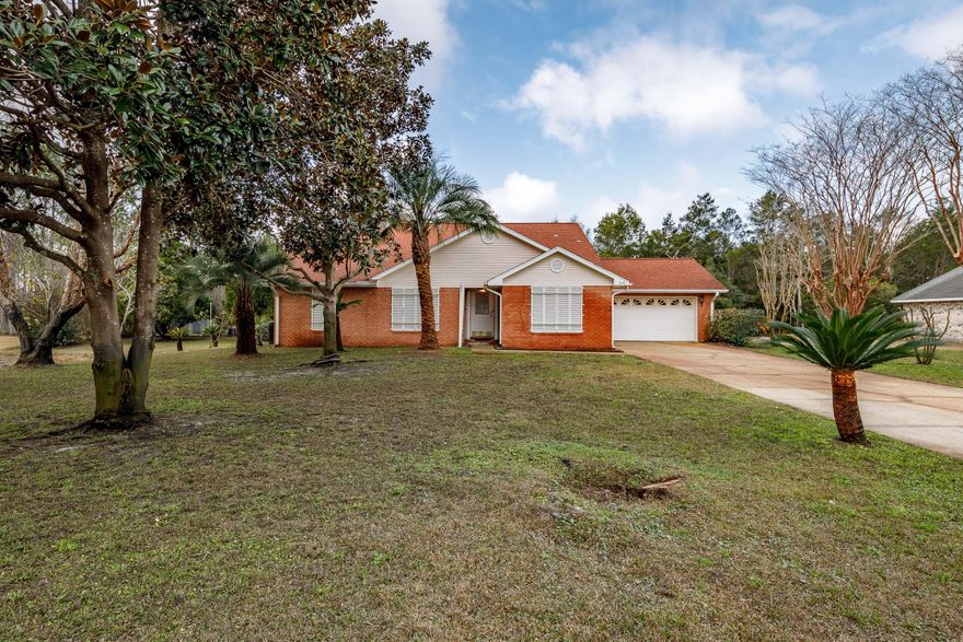 Come view this hidden gem in Spanish Trace Estates to truly appreciate all that it has to offer! This single owner home adjacent to a neighborhood lake is tucked away at the end of a serene cul-de-sac, and still in close proximity to all that Navarre has to offer. Check out the screenshot from the property appraiser's website to see the size of the large lot and property that could be yours. With 3 large bedrooms and two full bathrooms, fireplace, dining area, and breakfast nook off of the kitchen this home has endless possibilities! The hurricane shutters on the front windows have been opened but add an extra peace of mind for homeownership. Many wildlife guests have been known to visit the lake such as ducks, geese, beavers, and more- make an appointment to see this home in person today!