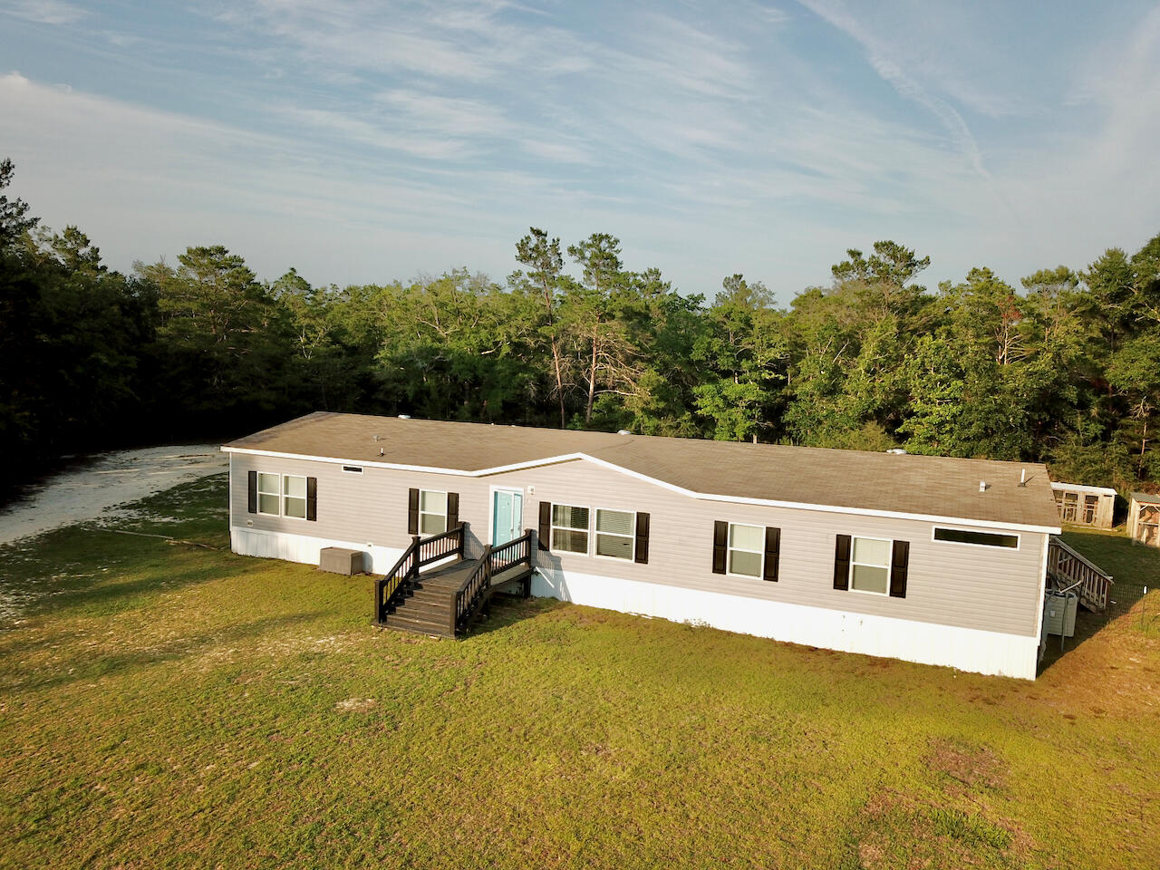 Welcome to 61 Kings Ct, a unique and charming property offering two separate dwellings nestled in the serene surroundings of DeFuniak Springs, with an approximate 220' of waterfront. This exceptional property features a modern 2018 year model manufactured home and a quaint cabin built in 2000, providing a blend of contemporary living along with the rustic charm.The main dwelling is a beautifully maintained 2018 trailer, offering modern amenities, and comfortable living spaces. Boasting 4 bedrooms, 3 bathrooms, and a spacious kitchen, this home is ideal for convenience and functionality. Step out the rear sliding doors on to the massive 18x40 sail cloth covered deck, and enjoy the privacy of your very own hot tub. The cabin offers rustic charm and character. With two bedrooms, two bathrooms, and cozy living spaces, this cabin is a true gem filled with potential for a variety of uses such as a guest house, rental, or an artists retreat. The rear screened porch is a great place to start the day, or wind down in the evening!
Nestled on a spacious 4.47 (Approx) acre lot, this property offers endless possibilities for outdoor enjoyment and relaxation. Whether you are entertaining guests, gardening, or simply enjoying the peaceful surroundings, this property provides the perfect setting for your lifestyle needs.
Don't miss your opportunity to make this unique property yours, and create your own haven in Walton County!
Schedule your showing today and experience the beauty and potential of 61 Kings Ct for yourself!