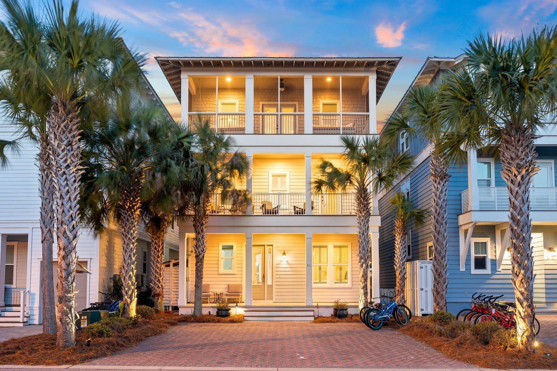 This three-story beach house in the heart of Seacrest Beach is all about location, location, location. Owners and guests have direct access to the resort-style lagoon pool, amphitheater and green space beyond the paved patio in the back of the home. The renowned shops and eateries on 30A are a short walk or bike ride away along with outdoor entertainment, a farmers market and amenities at Alys and Rosemary Beaches. Leave your vehicles on the paved frontage and you can easily get around by tram, on foot or on two wheels. Inside, the home has fresh bright appeal with hardwood flooring gracing the open floor plan. The sitting room is an inviting space for watching TV while relaxing on the sectional sofa.