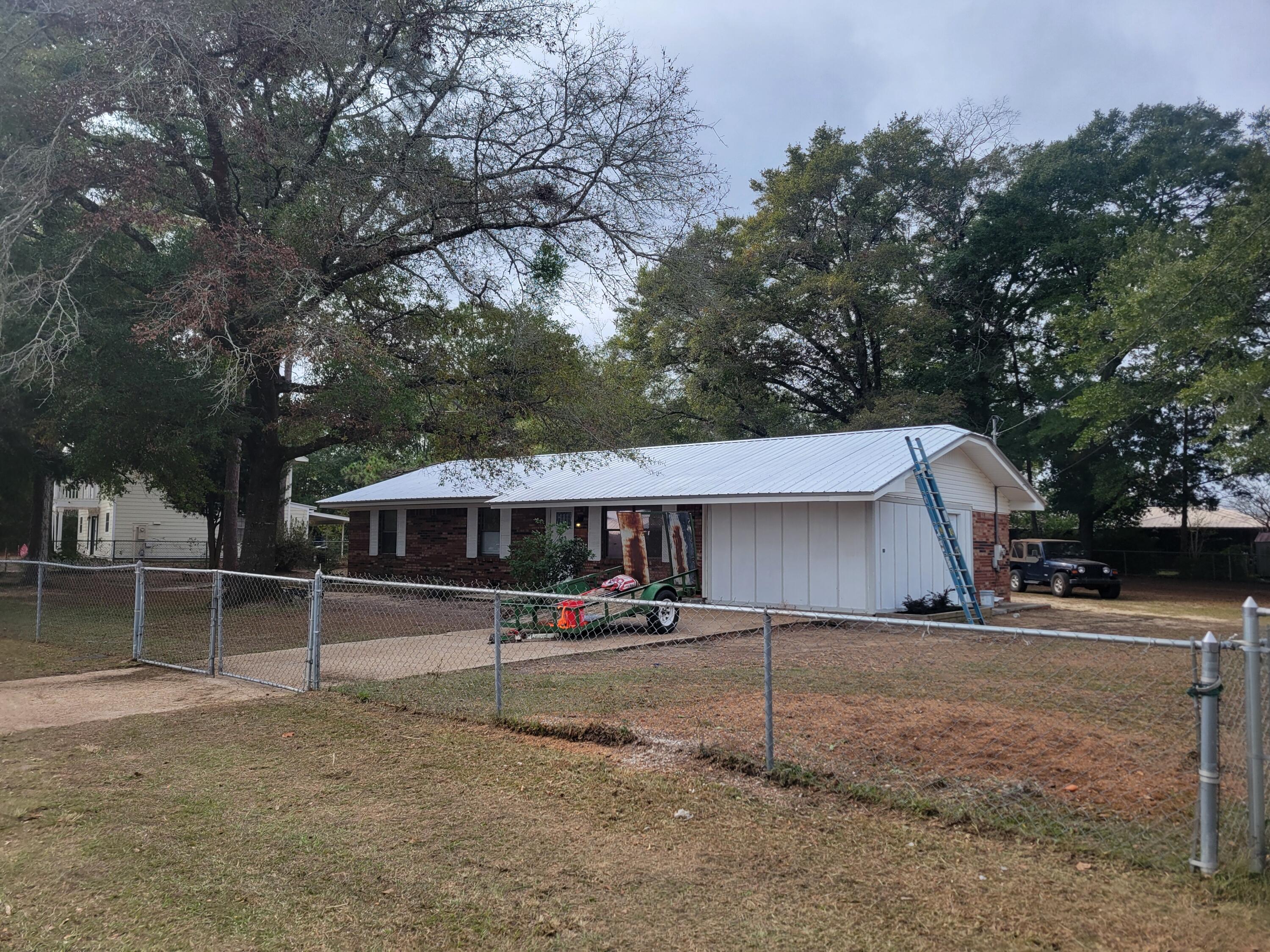 Brick home with new metal roof installed in 2022.  Seller has replaced the hot water heater in 2023 plus a brand new inside and outside HVAC system in 2023.  New flooring 2024 and freshly painted and turn key ready to move in! Converted garage to a 4th bedroom has an adjoining laundry room that could possibly be made into a 2nd bath.  Seller is offering $7,500 credit to Buyers towards closing fees (inclusive of title insurance and documentary stamps on the deed). The entire yard is chain link fenced allowing plenty of room for children and your pets.  Waterview of 'Back Lake' and 'Twin Lake' and short bike rides to 2 family parks.  ''Wee-Park'' is directly across from Walton High School and Maude Saunders Elementary and Back Lake Park on Shoemaker Drive.  Showings begin 12/09/2024.