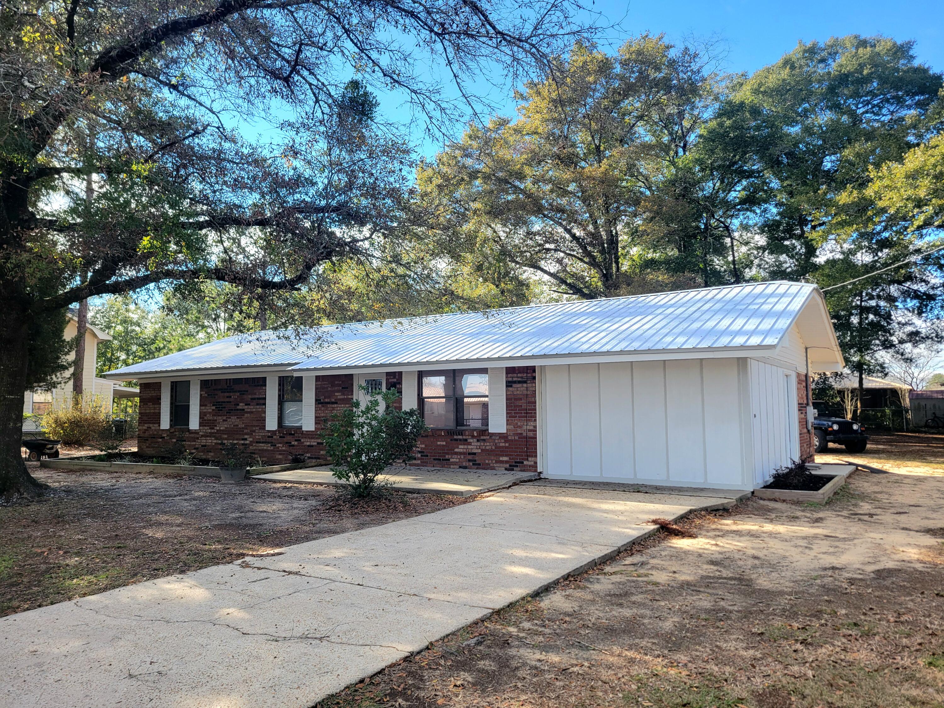 Brick home with new metal roof installed in 2022.  Seller has replaced the hot water heater in 2023 plus a brand new inside and outside HVAC system in 2023.  New flooring 2024 and freshly painted and turn key ready to move in! Converted garage to a 4th bedroom has an adjoining laundry room that could possibly be made into a 2nd bath.  Seller is offering $7,500 credit to Buyers towards closing fees (inclusive of title insurance and documentary stamps on the deed). The entire yard is chain link fenced allowing plenty of room for children and your pets.  Waterview of 'Back Lake' and 'Twin Lake' and short bike rides to 2 family parks.  ''Wee-Park'' is directly across from Walton High School and Maude Saunders Elementary and Back Lake Park on Shoemaker Drive.  Showings begin 12/09/2024.