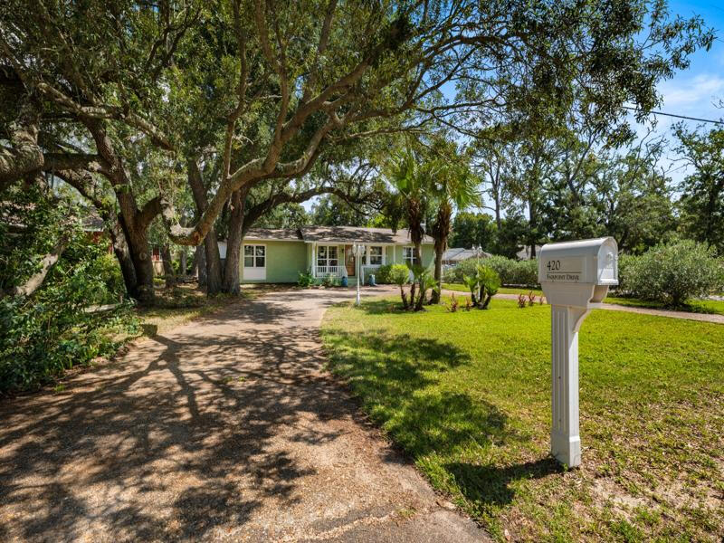 Move-in ready and full of charm, this historic Gulf Breeze Proper pool home was built in 1955 by the Berry family. It features original hardwood floors, quality craftsmanship, and a spacious 2016 Master Suite addition. The den impresses with a large stone fireplace, wainscoting, built-ins, and an 85' TV that conveys. Outdoor highlights include mature landscaping, a pool with new liner, bamboo Zen garden, and the original 'Summer Kitchen'a 300 sq ft outbuilding with A/C. Impact features provide low insurance costs. Located in Flood Zone X, this off-grade home blends history, comfort, and modern updates.Please Check out https://420Fairpoint.com for more information.