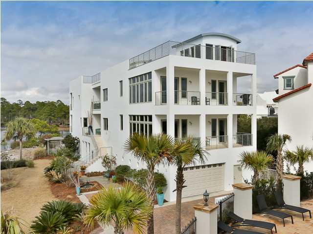 This unique lake-front home near the Gulf of Mexico is surrounded with breathtaking views of the gulf, white sandy beaches, Deer Lake State Park, and the beautiful ecology of one of northwest Florida's rare coastal dune lakes. The property's appeal can be immediately appreciated upon entering the brick-paved drive and glancing at the spectacular contemporary architecture! Constructed by Artisan Builders in 2002 and in excellent condition, the home totals +/-9,587 sf, with the heated and cooled living area totaling +/-5,089 sf. Each level has its own distinct attributes. Although this is a single-family residence, there are four separate living areas, each of which offer gorgeous views of the Emerald Coast. The first floor features a five-car oversized garage, a workshop, a studio or