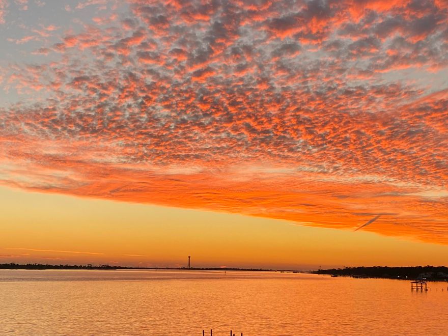 Sunsets, sunsets and more perfect sunsets!! Welcome to this beautiful waterfront getaway. This 3 Bed 2.5 Bath, 1,534 sqft condo is quite a find in this area. The unobstructed view is an even harder find. Year-round sunsets, waterfront pool & deck, dock slip with boat lift, the list goes on! Throughout you will find a fine wood textured porcelain tile. Wake up and step out onto the balcony with this exquisite view every morning. Condos can often have the issue of never having enough space for storage, not here! The space is cleverly put to use including a MASSIVE primary closet through the bathroom, large utility room with washer/dryer, kitchen with pantry and large outdoor storage. The large open living space with kitchen and wet bar is the ideal entertaining space for family and friends.