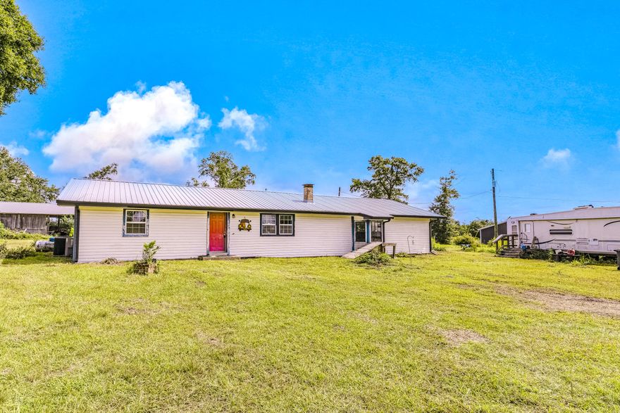 Country living at its finest - yet not too far out! This 3-bedroom, 2-bathroom home is situated on a sprawling 3.57 acre lot and features a desirable split-bedroom floor plan. Inside you'll find a space brimming with one-of-a-kind character, from the striking, custom-patterned wood plank ceilings to the rustic-chic blend of tongue and groove walls and corrugated metal in the kitchen and bath. The open-concept living area offers a welcoming atmosphere and a perfect canvas awaiting your personal touches to make it truly your own. The bedrooms are spacious and there is a separate foyer area. The expansive property is equipped with a versatile pole barn, covered porch, and an RV hookup, offering many possibilities for storage, work, or hobbies. The 2019 metal roof provides peace of mind. For recreation, you are just around the corner from Majette Park, which features a fantastic community center, nature trails, a disc golf course, and is slated for more exciting future upgrades. While you'll enjoy the serenity of your own space, you're still conveniently located just a short drive away from Panama City amenities ~ 6 miles to the nearest Publix, 12 miles to Gulf Coast Hospital, 24 miles to Northwest Florida Beaches International Airport (ECP), and only 21 miles to the iconic white sands of Panama City Beach! This is a rare chance to create your private haven with unbeatable space and potential.