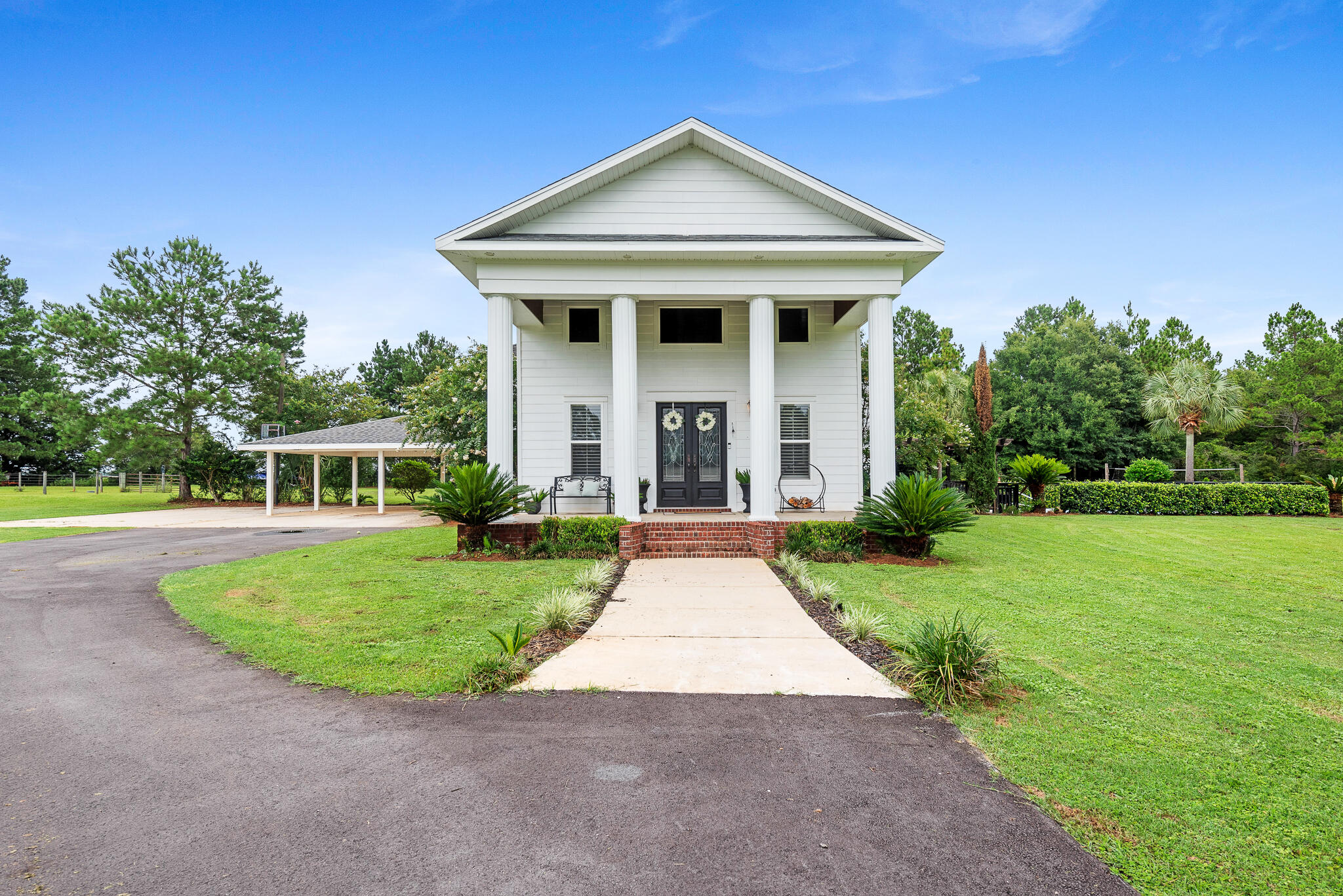 This beautiful, custom built home is situated on a large 7.3-acre lot with privacy. Wake up to the serene sight of deer grazing in your yard, surrounded by native landscaping featuring beautiful azaleas around the perimeter. You'll have the perfect spot for gardening. Enjoy evenings out by the pool under the pergola. The property offers peace & tranquility & it's conveniently located just 45 minutes away from the beach & Pensacola. Inside, there are 4 bedrooms & 3.5 baths & most of the bedrooms feature charming shiplap walls.  As you walk in, you'll immediately notice the oversized staircase & fireplace as focal points in the living room. Additionally, there is a 2-acre fenced pasture with water, perfect for any livestock or horses.