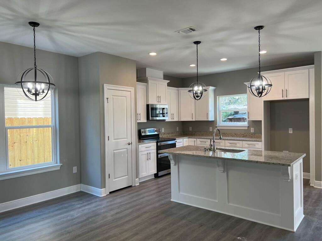 NEW CRAFTSMAN Custom Built Home in EAST NAVARRE~Under construction and ready for your summer move in ~Great Location with easy access to Navarre Beach ,local stores & Hwy 98 to Hurlburt Field AFB.This Stunning Robbins Builders Home offers trend setting Features~Greeted by a walk in foyer sweeping through to your open floor plan~Large kitchen enjoying all wood white Shaker cabinets with crown molding, beautiful GRANITE counter tops~Under mount sink~S/S appliances~Center Island or breakfast bar ,offering plenty of work area & open flow to the dining area and large family room.Gorgeous luxury vinyl plank flooring throughout. Master bedroom is a great size with & Large Master bathroom offering ~ oversized TILED walk-in shower ~Granite vanities with rectangular under mount sinks