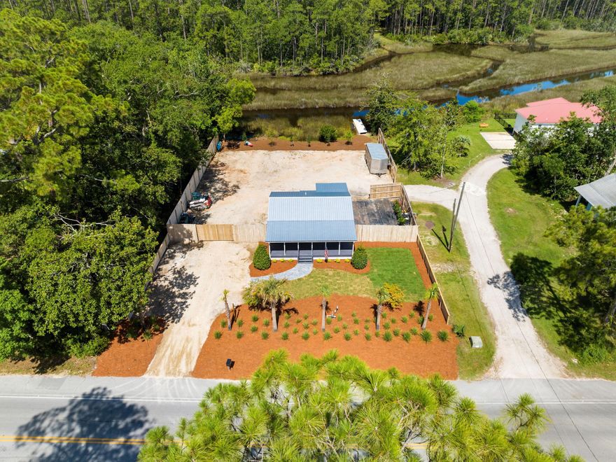 Enviably located on a large lot, this fully updated home has direct water access and is just 0.2 miles from Cessna Landing public boat launch. Located on the 30A corridor, it is within easy reach of Gulf Place shopping, dining and entertainment. The entire home has been completely updated from the flooring and paint to new landscaping. It boasts a newer metal roof, secure fencing and an updated front porch. The kitchen and bathroom have been completely redone, creating a home that's move-in ready for a first-time buyer, second-home owner or investor. From the lengthy driveway, a paved path winds through the landscaping to a shady front porch, which extends across the full width of the home. Indoors, the open concept floor plan is a blank canvas for new owners to add their own individual touches. Neutral walls and LVP flooring are illuminated by several windows along with recessed lighting. The bright new kitchen is tucked away behind an island breakfast bar. White floor-to-ceiling cabinets and stainless steel appliances make this a well-planned workspace complete with a glass-topped stove and French door refrigerator.  Doors lead to two spacious bedrooms, useful storage closets and a sparkling new bathroom with a frameless glass shower. The rear yard is securely fenced and very private.  Relax on the covered rear porch and enjoy the peaceful sounds of nature in this unspoiled haven. The property has ample storage and space for watercraft, parking or even adding an additional home. For water lovers, a boardwalk that won't need a permit to be built, provides access to the water for launching kayaks and paddle boards. Best of all, there is no HOA. When the 30A lifestyle beckons, there's a wide choice of breakfast cafes and popular eateries nearby including the Perfect Pig and Shelby's Bar and Grill. All this, just three miles from white sandy beaches and Ed Walline public beach access.