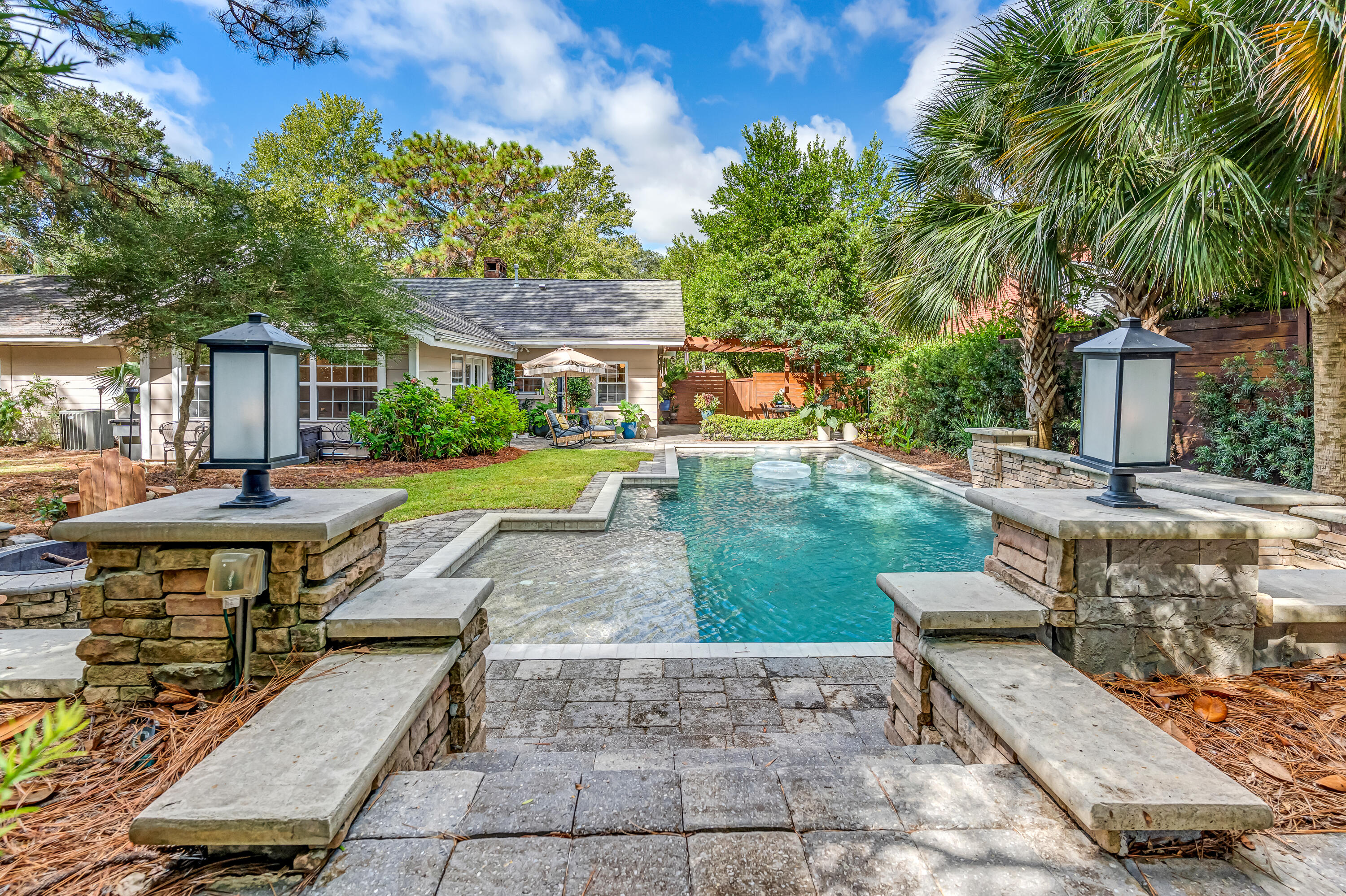 Seller to replace roof with acceptable offer! Welcome to your very own Sanctuary. Your very own private backyard oasis awaits with mature trees and native sourced landscaping. Enjoy a heated, custom-built pool with a waterfall, surrounded by open patios ideal for gatherings, plus a fire pit that invites year-round enjoyment. This home blends sophistication, warmth, and resort-style living all in one.Step into timeless elegance with this beautifully appointed home, where classic charm meets modern comfort. Inside, the living room features custom built-in bookshelves and a cozy gas fireplace, creating the perfect space to unwind. The kitchen is a chef's delight with a gas range, quartz countertops, white subway tile backsplash, and tall custom cabinetry that maximizes storage in style. Gorgeous hardwood flooring flows throughout, complementing two spacious living areas that offer plenty of room for relaxation or entertaining. This beautiful home and property are located on a peaceful, tree lined street, across from secluded Garnier's Bayou and steps away from Longwood community park on the bayou. Bring your paddle board or kayak and enjoy a day on the water or just an evening paddle.