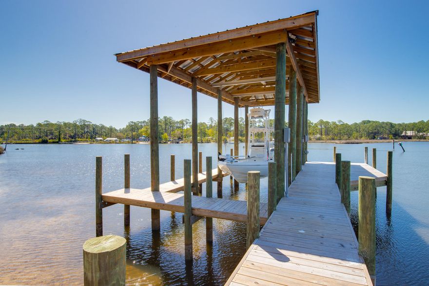 This may be the perfect time and the perfect place to bring your plans and boat to a fabulous lot on a sought after Bayou. Cessna Landing is a gated neighborhood, and you have choices on more than a third of an acre of where to situate your new home. Usually, someone builds a house, then the dock, then acquires a boat. It's in reverse here. Dock built by Frank Davis. Covered slip is 28' long.Electricity and plumbing in place. Bring your boat tomorrow. Enjoy the dock, sunsets and water while you build a waterfront residence. The beach is less than four miles down the road, and this special retreat will bring years of boating enjoyment. Most folks looking to build on waterfront must factor in $60k for a covered boat slip and powered boat lift. This waterfront site has all that in place.
