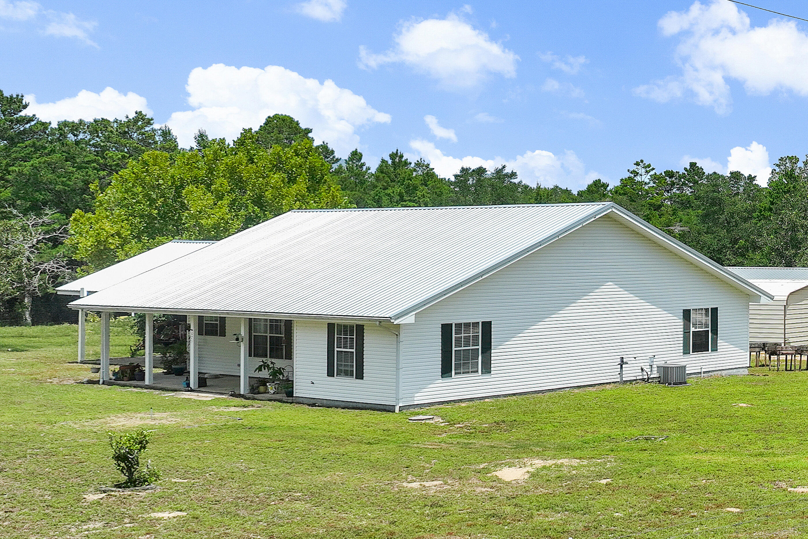 Beautifully Updated Home on 4.5 Acres!This peaceful 4.5-acre property offers the perfect blend of privacy, comfort, and functionality. The open-concept home features two spacious primary suites, an extra large front porch, and a newly renovated kitchen with quartz countertops, custom tile work, floating shelves, new appliances, and updated lighting. A separate suite with a kitchenette, gas range, commercial vent hood, and built-in grill provides flexible living or guest space.Outdoors, enjoy: Outdoors, enjoy:
- 2+ acres of mature trees with a walking trail
- 2+ acres of fully fenced pasture divided into 3 sections ideal for livestock or gardening
- Stables and chicken coop
- 24x60 barn/workshop with power
- 18x25 insulated storage building with power
- Full RV hookups and separate septic system
- Private well + public water access (meter in place, tap fee required)
Attached covered parking and wide-open skies complete the picture. Just 25 miles from the white sand beaches of Destin, 20 miles to Niceville, 15 miles to Crestview, and 10 miles to downtown Defuniak Springs. "Finca del Sol", Ranch of the Sun, is a rare opportunity to own a move-in ready homestead with room to grow.