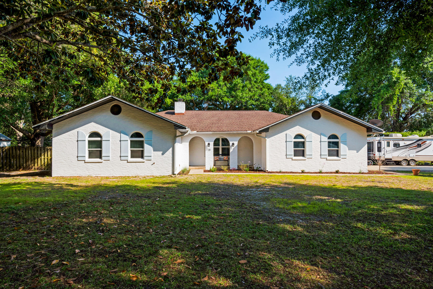 One Floor Living with Screened Swimming Pool on Quiet Street /Single floor living is convenient and attractive, and this stylish home on a mature tree-studded double lot showcases the best of outdoor living in Florida. The curb appeal is fresh and inviting with a side entry garage on a corner lot. The heart of the home is a bright, modern kitchen with white cabinets and a large farmhouse sink with the requisite kitchen window over it. Brushed nickel hardware, gleaming stainless steel appliances and new quartz countertops make a bold fresh statement. The center island offers more storage plus a breakfast bar. Tile flooring flows into wood laminate in a cleverly designed open dining space and living room separated by a half wall. Cathedral ceilings and wood beam accents add a nice flair