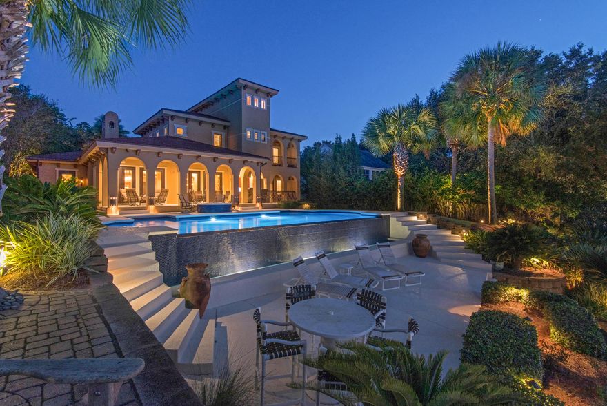 This magnificent private waterfront estate resides on Pensacola Bay, in Gulf Breeze. This home offers infinite sunset views, ample entertaining space and a gated entry. You'll enjoy multi-tiered levels of outdoor living space, infinity pool, full outdoor kitchen, two separate fire pits, (gas & wood burning) and a secret place to watch the sunset over the Bay. This home is built on a bluff with 24 feet of elevation and steel frame construction with no expense spared. You'll note the Mediterranean design influence, the hand crafted iron gates and Mahogany doors throughout the home, imported from Brazil. The Chef's kitchen comes equipped with Viking Professional appliances, 6 burner gas hood range stove with warmer lamps, butlers pantry, additional walk-in pantry and 2 trash compactors. The b