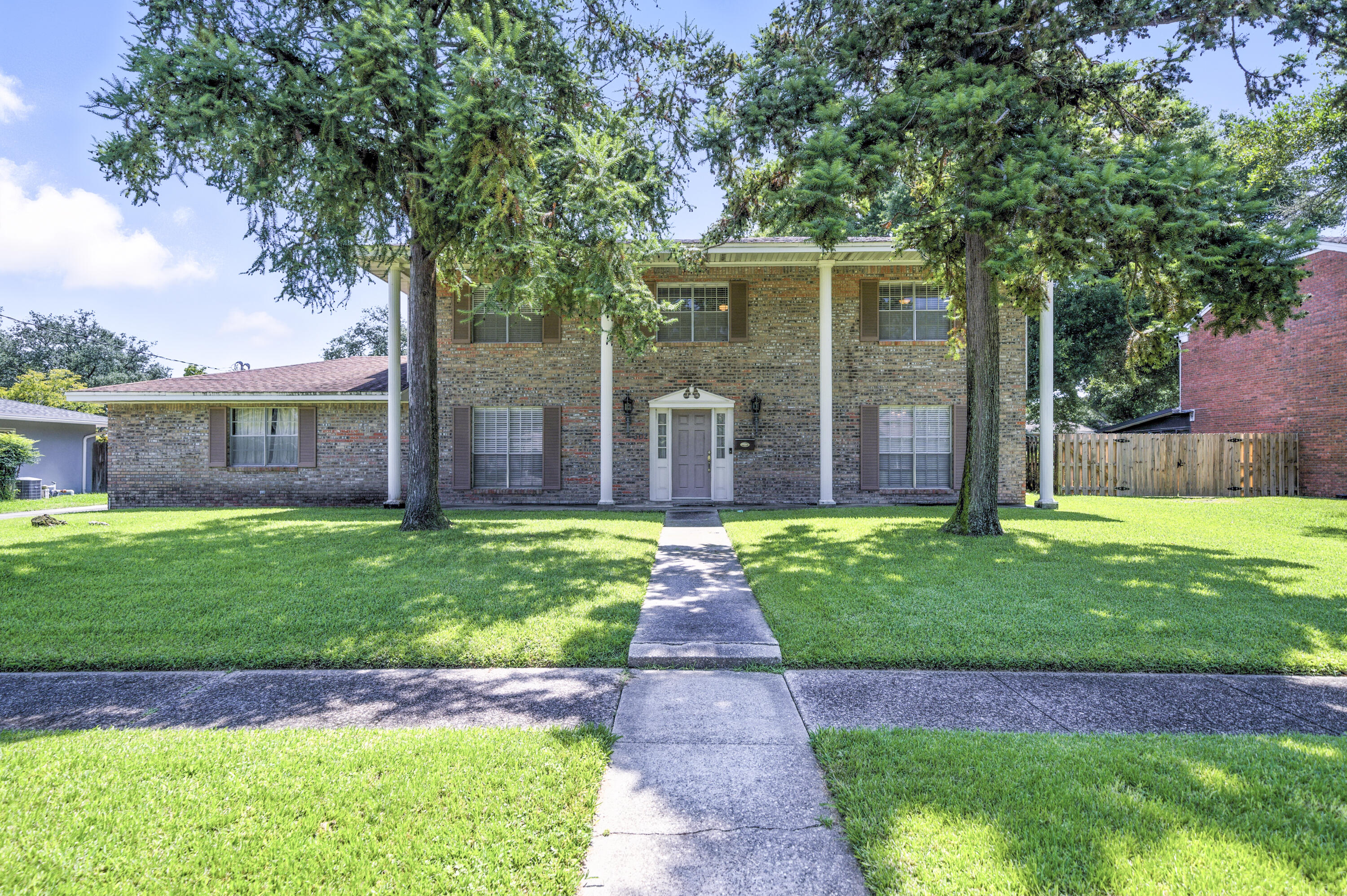 Welcome to 302 and 302A Briarwood Circle. THIS IS THE HOME YOU HAVE BEEN LOOKING FOR WITH A RENOVATED MOTHER-IN-LAW SUITE! This spacious property offers a total of five full bedrooms plus a flex room and four full bathrooms - perfect for multi-generational living, extended guests, or rental potential. With over 3,400 square feet of living space and classic Southern Plantation-style curb appeal, this home offers space, character, and comfort.The attached Mother-in-Law Suite (or carriage house/guest quarters) was built in 2012 and includes one bedroom and one full bathroom. It comes with its own full kitchen and living room. Features include a high-end kitchen with Kenmore stainless appliances, granite countertops, an undermount double-bowl sink, and custom cabinetry. Other features include smooth ceilings, crown molding, recessed lighting, and pendant lighting. The suite offers its own private entrance (as well as interior access), its own electric meter, and numerous ADA-friendly features. The bathroom is oversized with a glass-door shower, soaking tub, comfort-height toilet, double vanity, and a washer dryer hook up. ( stackable washer and dryer not included). The bedroom has double closets, a ceiling fan, stained glass transom, and room for a king-size bed. This space also includes its own instant hot electric water heater and separate HVAC system (age 2012).
The main residence includes four bedrooms, a flex/office room (located upstairs and could easily be converted into another small bedroom with bunks), and three full bathrooms. Off the entry foyer, you'll find the living room and dining area. The kitchen is generous in size with an island featuring breakfast bar seating, and the French doors that lead to the guest suite. Upstairs, you'll find the oversized primary bedroom, three additional bedrooms, and the flex room. The main home is equipped with its own HVAC system, which was replaced inside and out in 2025. The electrical panel was also updated in 2023.
The home is on a great sized lot and includes a rear-entry two-car garage with built-in cabinetry, plus an additional covered carport ideal for storing jet skis, boats, motorcycles, or extra vehicles. The extended driveway offers ample parking, and the mature landscaping throughout the yard adds curb appeal.
Located just a few doors down from Briarwood Park and close to Sam's Club, Walmart, and other local conveniences, this home offers a rare opportunity to live in one space while updating the other. No flood zone. Schedule your showing today!