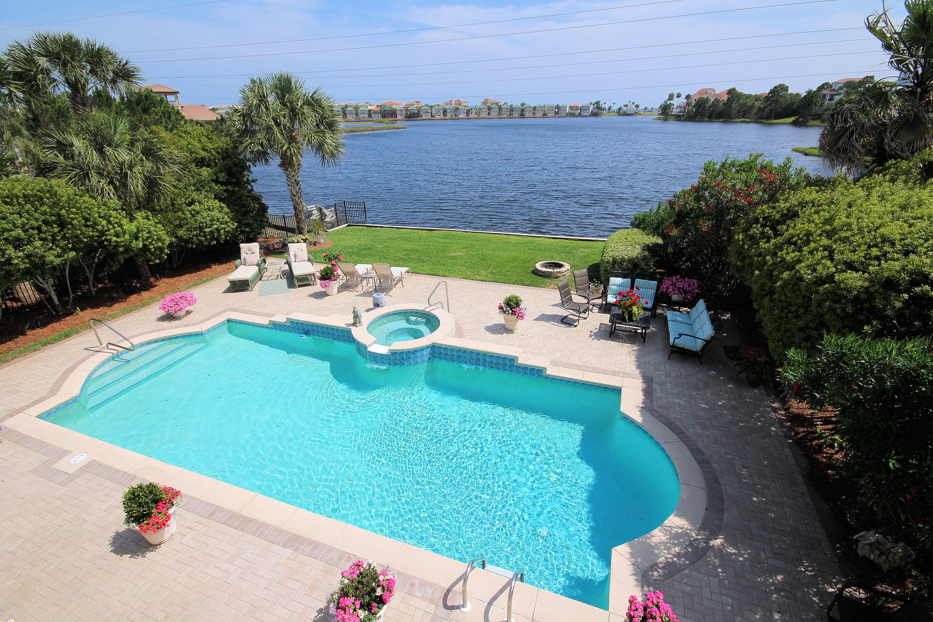 This could be your view! This lovely custom lakefront home in the popular gated community of Destiny East boasts fabulous views of the lake and Gulf. You'll enjoy your outdoor living by the pool and spa as the sun sets on the lake. Six bedrooms and pool will make this home a great rental or full time residence/second home. The coastal decor features gorgeous polished travertine floors throughout the two living areas & kitchen as well as beautiful white marble counters in the kitchen & master bath. There is an office upstairs, & one bedroom downstairs can also be an office. Stainless appliances and glass tile backsplash look wonderful in this coastal kitchen. Destiny East is a short golf cart ride to the beach, and has a wonderful clubhouse with a gym, theater, 2 swimming pools, lighted tennis courts, playground, basketball court, as well as many homeowner activities and holiday parties.  It is in the heart of Destin, close to shopping, golf, restaurants, entertainment.  New AC 2012.  Buyer to verify all measurements. Being sold unfurnished.  