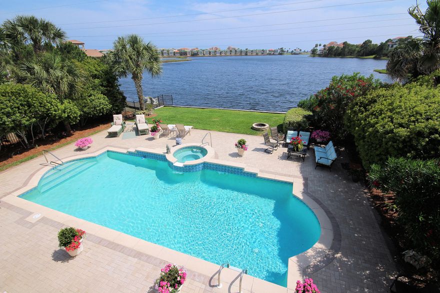 This could be your view! This lovely custom lakefront home in the popular gated community of Destiny East boasts fabulous views of the lake and Gulf. You'll enjoy your outdoor living by the pool and spa as the sun sets on the lake. Six bedrooms and pool will make this home a great rental or full time residence/second home. The coastal decor features gorgeous polished travertine floors throughout the two living areas & kitchen as well as beautiful white marble counters in the kitchen & master bath. There is an office upstairs, & one bedroom downstairs can also be an office. Stainless appliances and glass tile backsplash look wonderful in this coastal kitchen. Destiny East is a short golf cart ride to the beach, and has a wonderful clubhouse with a gym, theater, 2 swimming pools, lighted tennis courts, playground, basketball court, as well as many homeowner activities and holiday parties.  It is in the heart of Destin, close to shopping, golf, restaurants, entertainment.  New AC 2012.  Buyer to verify all measurements. Being sold unfurnished.