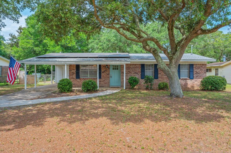 Welcome to this beautifully renovated single-story, three-bedroom, two-bath brick home located in the heart of Fort Walton Beach. Step inside to find luxury vinyl plank flooring throughout and elegant custom molding in the entryway, living room and hallway. The updated white kitchen features stone countertops, stainless steel appliances, and built-ins, opening to a separate dining room accented with a barn door that leads to a mudroom and laundry area--both offering additional custom built-ins. Enjoy modern comforts with ceiling fans, a spacious guest bathroom with a large vanity and custom lighting, and a luxurious tile walk-in shower in the master suite. Natural light pours through the home, creating a warm and inviting atmosphere. Monthly electric/solar fee applies. Step outside to a backyard oasis with a covered patio adorned with charming Edison lights, mature trees for added privacy, and a storage shed. A front carport and ample additional parking make this home as functional as it is stylish.