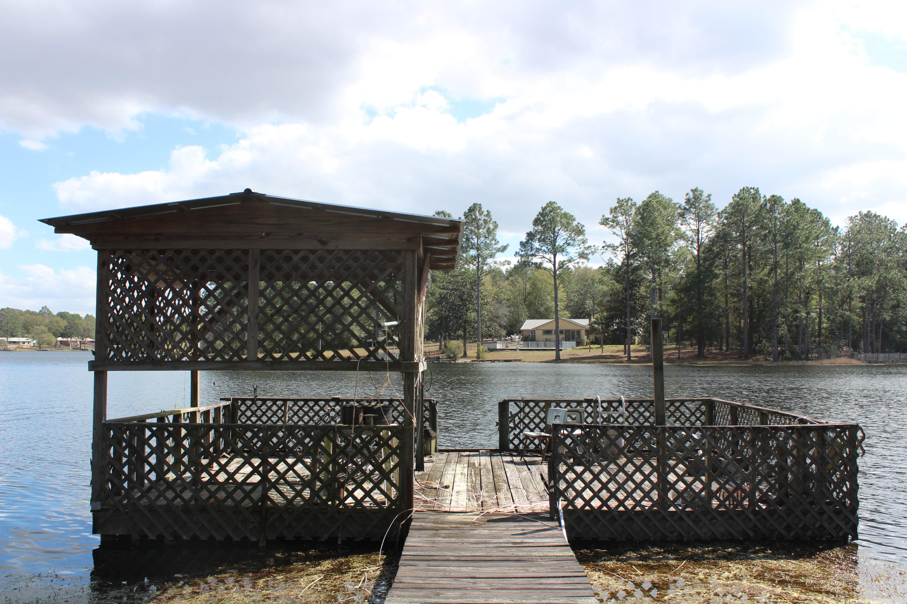 WATERFRONT PROPERTY ON JUNIPER LAKE. JUNIPER LAKE IS KNOWN TO BE OVER 600 ACRES OF GREAT FISHING OF LARGE MOUTH BASS, BLUE GILL, CATFISH & BREAM. MAKE THIS YOUR GETAWAY RETREAT HOME OR YOUR LAKEFRONT HOME. THIS 2 BEDROOM HOME HAS A BOAT PIER A SCREEN IN PORCH LOOKING AT THE LAKE. A METAL CARPORT THAT CAN FIT 2 CARS AND A SHED FOR MORE STORAGE. THERE IS ANOTHER STORAGE ROOM BUILT NEXT TO THE HOME. HOME IS FURNISHED HOWEVER DOES NEED SOME WORK TO MAKE IT YOUR HOME. EVERYTHING STAYS IF YOU WANT. SMALL BOAT, FISHING GEAR, KITCHEN DISHES...YOU NAME IT! HOME HAS BEEN USED A A RETREAT HOME AND NOT OCCUPIED ALL YEAR LONG. SELLER IS RELATED TO AGENT. CASH DEAL ONLY. SOLD AS-IS. BUYER TO VERIFY ALL INFORMATION