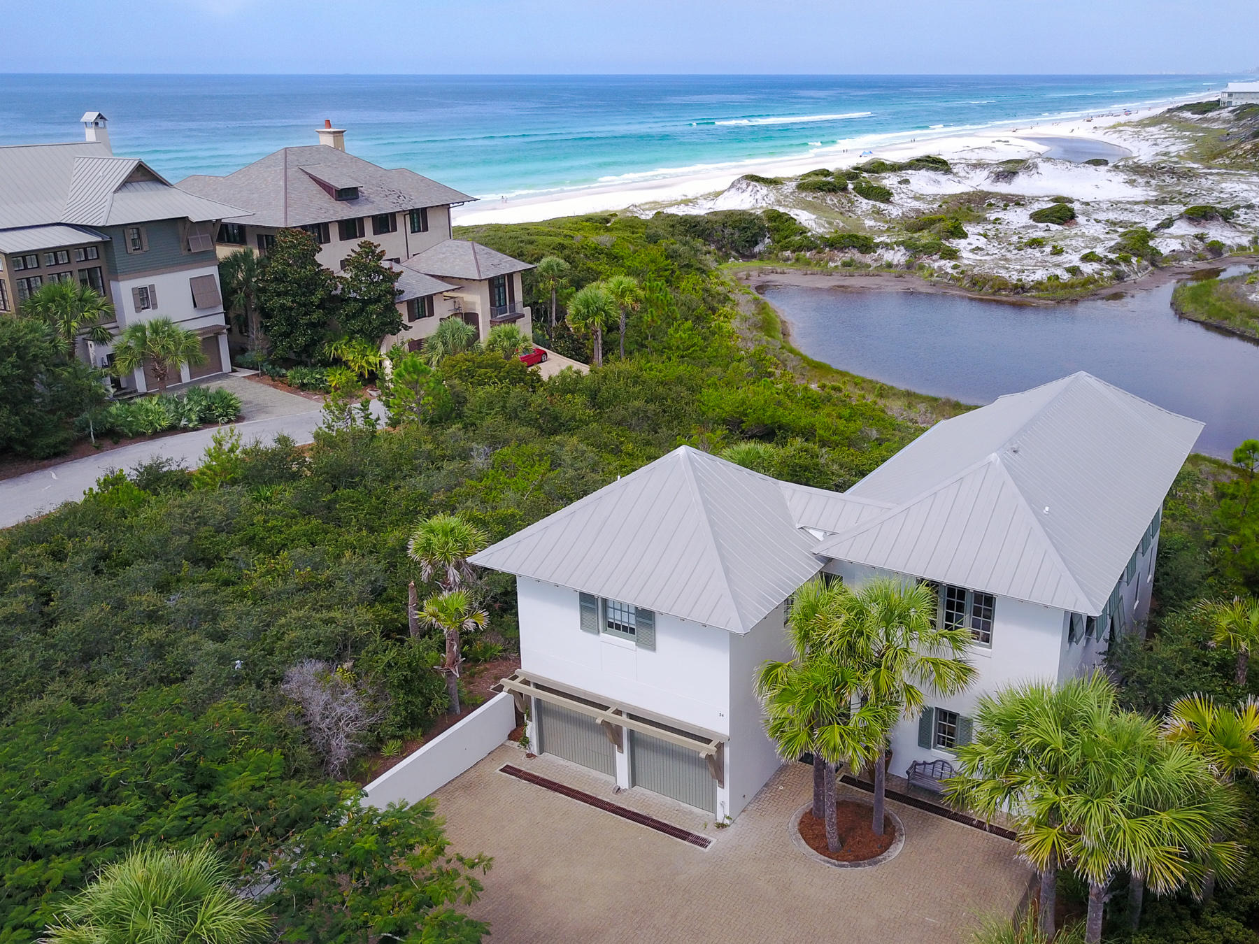 Step into the entryway of this tranquil, private courtyard overlooking the white sand of a rare coastal dune lake and spectacular views of the Gulf of Mexico. Nearly every room of this 2,314 Sq. Ft. home offers incredible vistas that you can only get from the Emerald Coast. This seaside home has 3 bedrooms, 3.5 bathrooms and a bunk room for visitors and guests. A spacious 2-car garage and a large private driveway provide plenty of room for hosting guests and entertaining. Lavish finishes and amenities like wide plank hard wood flooring, granite counter tops, steam tile showers, GE stainless steel appliances and high, wood beamed ceilings are found throughout this home.