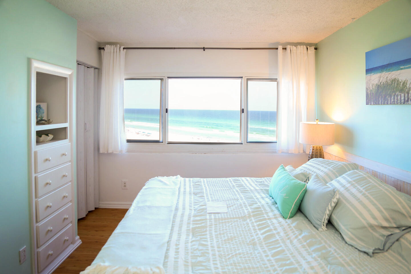 Escape the crowds and experience the tranquility of this secluded condo located at the western end of Panama City Beach, between Carillon Beach and Camp Helen State Park. Nestled in a peaceful, private setting, this is the perfect spot for those seeking a quiet retreat, while still being just 8.5 miles from Seaside. This charming turnkey/move in ready two-story condo (1 bedroom, 2 full baths) offers over 880 sq. ft. of living space, comfortably accommodating up to four adults. It features stunning views of both the Gulf of Mexico and Lake Powell, and has been professionally decorated and frequently updated to feel like a true home away from home. Inside, you'll find a master suite on the lower level with a king-size bed, a large closet, and a stunning Gulf view from the bedroom window. Upstairs, the spacious living room opens to a balcony with sweeping views of Lake Powell. It's equipped with an entertainment center, a large flat screen TV, ceiling fan, and a queen-size sleeper sofa. Fees include internet and water as well.
The second full bath upstairs was an upgrade from the half bath that most other respective units have. There is also a stackable washer and dryer in the upstairs hall that is included in sale. The gourmet kitchen is fully equipped with modern appliances, including a dishwasher, refrigerator, microwave, and stove. It's perfect for preparing meals, and comes with added extras like pots and pans, utensils, coffee/espresso machine, and toaster. The dining area, with its beach view table that seats 4, offers a spectacular view of the Gulf from the large window.
Located in a gated, family-friendly community with 24-hour security, this condo provides the perfect mix of privacy and convenience. It's a rare find on Panama City Beach, offering an ideal getaway or rental opportunity that is turn-key and move in ready.