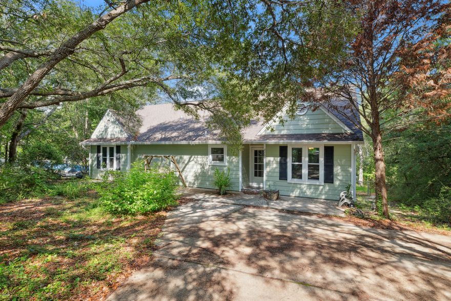 Tucked away in the peaceful Tom King Estates neighborhood of Navarre, this charming and whimsical 2 bedroom, 2 bathroom Florida cottage awaits! Offering a rare blend of privacy, nature, and character - seemingly right out of a storybook! Take a stroll down the winding natural path in the backyard to a quiet creek that gently spills into Tom King Bayou, providing a tranquil setting for your morning coffee or nature observing. Inside, you'll find a cozy yet open floor plan with a charming wood-burning stove as the centerpiece for the living area. The kitchen features a breakfast bar that looks out into the living room and to the French doors that lead you to the expansive screened in patio - setting the scene for the perfect backyard entertaining space! The primary bedroom also offers french doors that lead to the raised open deck in the backyard and the most magical view of the backyard, as well as its own walk-in closet and ensuite. The additional full bathroom is just down the hall from the second bedroom which also has an AMAZING, oversized walk-in closet. With no HOA, AND ownership granting the ability to buy into Crab Inc. to gain access to a boat launch, beach access, and picnic grounds - this home is one of a kind and waiting for you to make your next primary residence or the most unique investment property!