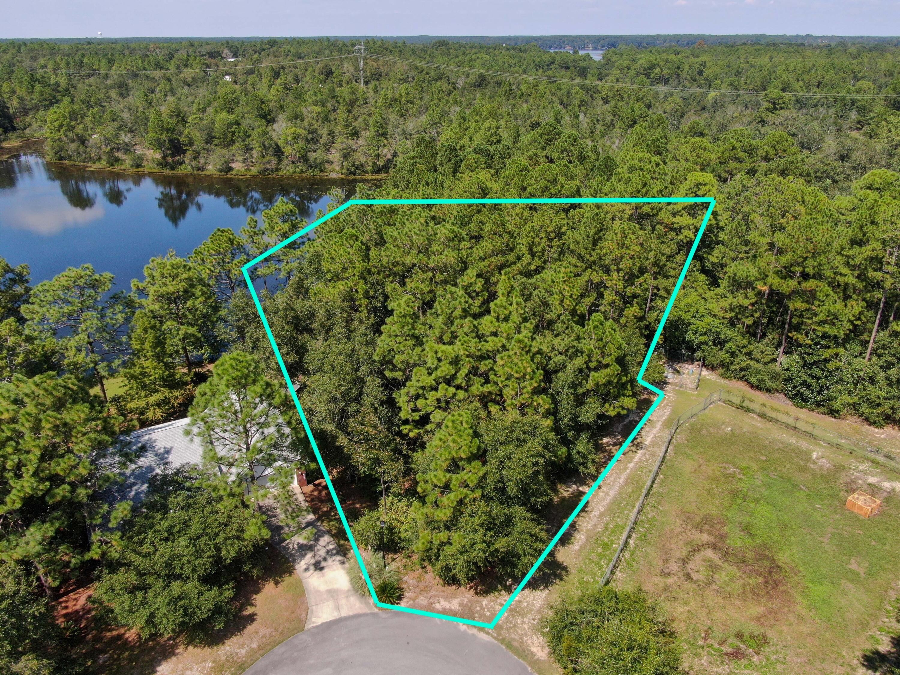 Rare Oversized 1.3 Acre Waterfront Lot on a Cul-de-sac with a whopping 225 waterfront feet. Located in popular Magnolia Lake Estates, a small neighborhood in the city limits of DeFuniak Springs, a mere 5 minute drive to the historic and charming downtown. Still mostly wooded but some underbrush has been cleared so you can walk down to the water. The adjacent property is owned by the city with retention area and lift station, so no one will ever build on that side. The size & location ensures you can build the home of your dreams in the ideal private and secluded location. Located close to schools, parks and shopping with only one entrance in/out for a more protected neighborhood environment. Electric, public water, sewer, natural gas & high speed internet available. (tap fees unpaid).