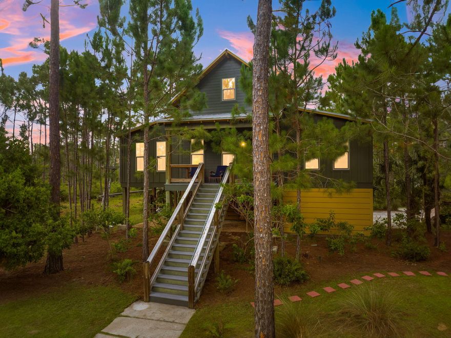 Discover the serene beauty of 7707 Magnolia Pond Trail, a stunning 3-bedroom, 2-bathroom home nestled on 1.8 acres in the desirable RiverCamps community of Panama City Beach, FL. Spanning 2,108 square feet, this spacious home offers a perfect blend of modern amenities and rustic charm. As you approach this elevated home, the inviting front porch welcomes you, providing a perfect spot to enjoy the tranquil surroundings. Inside, the open-concept living area features high ceilings and abundant natural light, creating an airy and welcoming atmosphere.