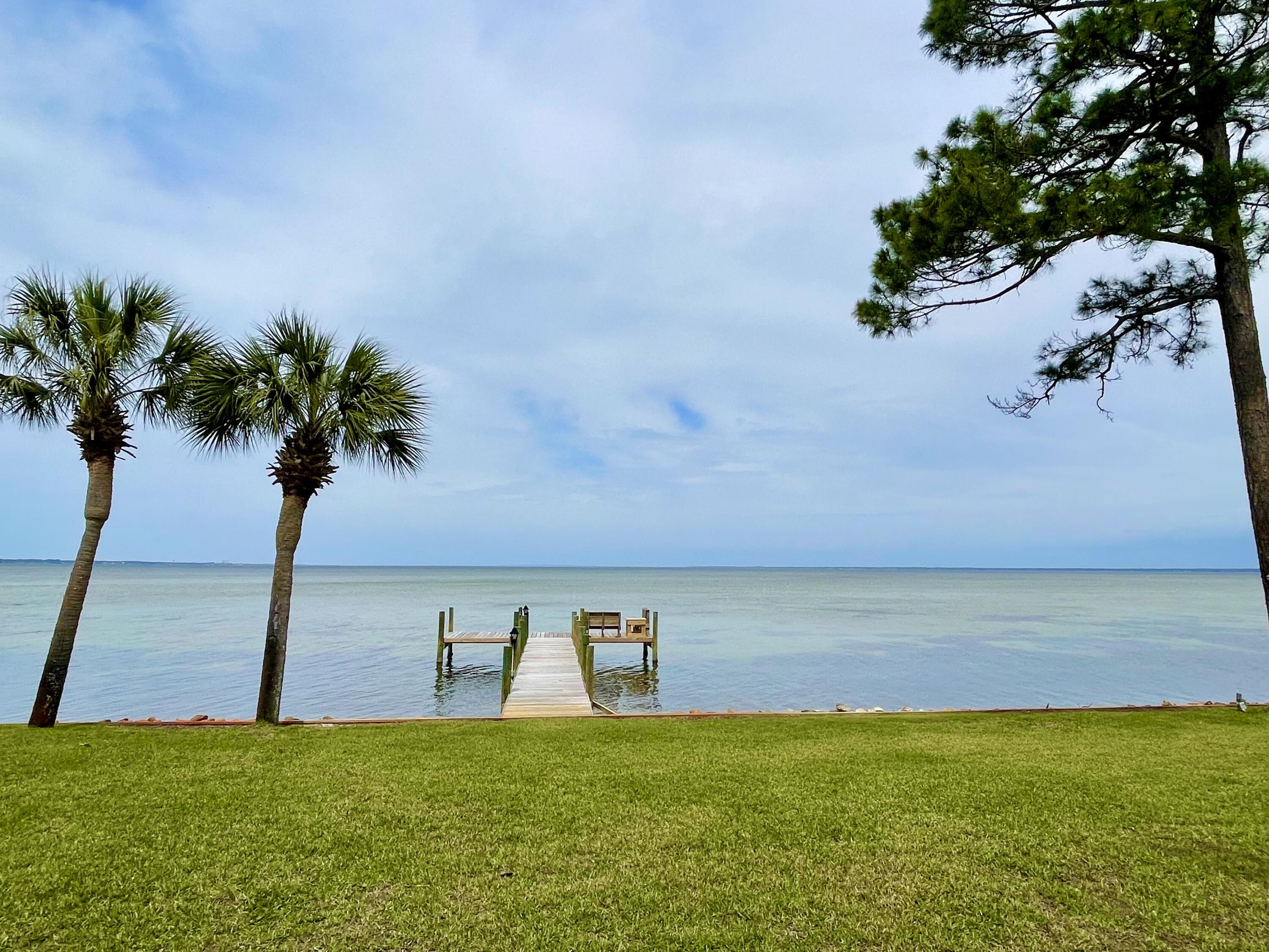 Located in prestigious Burnt Pine on the highly coveted Bay Estates Circle, this Mediterranean home sits on one of the few estate size bayfront lots. Offering a stately porte-cochere upon arrival, this home was designed by Architect David Hewell, Atlanta, Ga. and built by CD Jones.  Entering this home, you are greeted by beautiful Italian marble under your feet and a panoramic waterfront view in your sights.  3219 features an open concept living and expansive nightly sunsets. The kitchen cabinets and countertops were updated in 2021. The master suite is on the first floor with the remaining bedrooms on the second floor. There is also a kitchenette and balcony on the second floor perfect for morning coffee or evening sunsets.