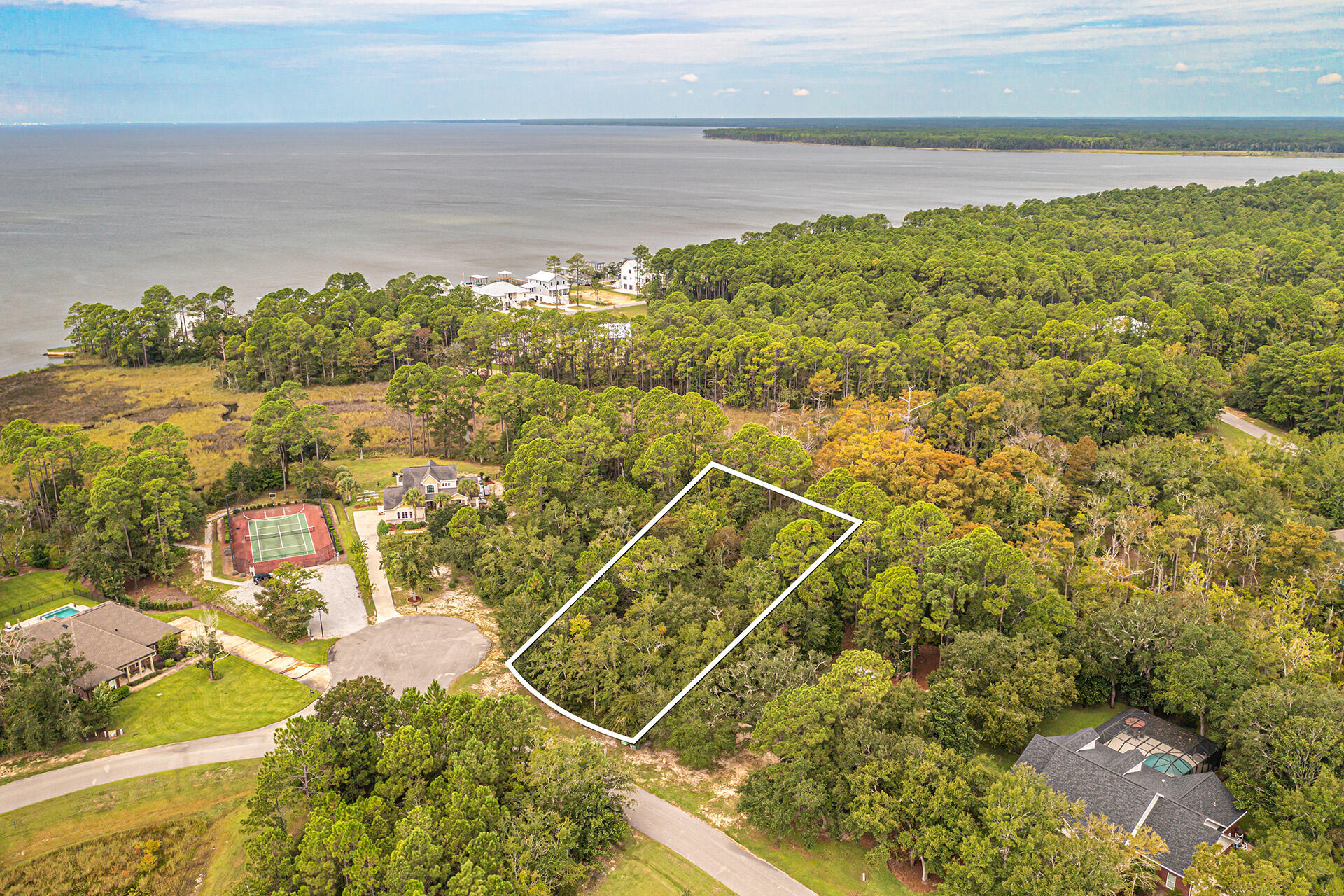 Welcome to a rare opportunity in the heart of Bay Harbor. This vacant lot not only offers a view of the bay but also has the added allure of being just steps away from a meticulously maintained tennis court, an inviting boardwalk, and a private dock. Imagine building your dream home here, where every day begins with breathtaking sunrises and ends with serene sunsets over the water. This isn't just a property; it's a gateway to a lifestyle of coastal elegance and active leisure. Seize the chance to own a piece of Bay Harbor's beauty and create a legacy with a view that inspires.