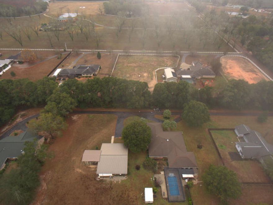 NEW PRICE ! Serenity and country living awaits you and located close to main access points, such as I-10 and highway 90. This acerage property includes a 40x60 workshop that will house an RV, boat, trailer and more. The shop is partially enclosed with a bathroom and A/C window unit. There is an in ground, enclosed swimming pool, a sprinkler system and a 660 foot deep well that has plentiful and clear water. The home is accessed by black top road and driveway and a circular drive for additional parking. Inside, you will find a rambling Ranch style home with 4 bedrooms and 3 bathrooms that was custom built by the current owner. There is 2 separate living areas and a sun room overlooking the pool area. The floor plan is well planned, has a huge laundry area & extensive,solid wood cabinetry.