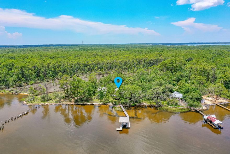 It's a dream home for boaters, water enthusiasts and paddle boarders with direct water access from the bay front lot and dock. This two bedroom two bath house sits on over 1.5 acres  and offers 84 ft of water frontage. Large second floor billiards room could be converted into a third bedroom. Above the single car garage has unfinished space that could easily be transformed into an additional bedroom. Rip rap and custom dock with a boat lift already in place for your enjoyment.  This property includes two other platted lots that border a bayou.