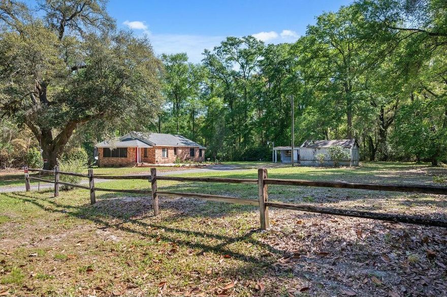 Lush Acreage close to everything. Imagine all the possibilities with this beautiful 1.83 acres, Home is built in 1943 and still maintains much of the mid century charm. Dark wood stained trim throughout including cased windows, original hearth and designated rooms for privacy. The home has a 5 year old roof, newer water heater and HVAC, Back covered porch is perfect for those lazy afternoons. The property itself has 2 out buildings, active creek, lush fruit trees and oversized chameleons as well as other beautiful foliage. Homes in flood zone X, it is livable, however being offer AS IS. All measurements and details to be verified by buyer.