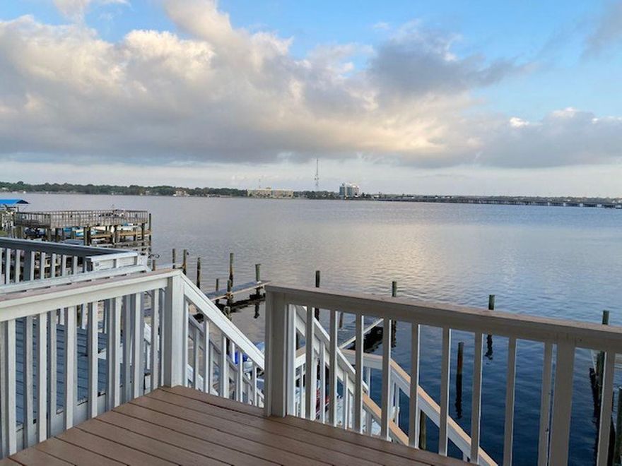 WATERFRONT unit that has been fully renovated with a deep water boat slip! Everything has been renovated from the kitchen, flooring, high impact windows and sliders, bathrooms, showers, fireplace... all the way down to the fans, lighting, light switches, and door knobs. A third bedroom has been added to accommodate extra guests or serve as a study. The kitchen and living area have been renovated to make it open concept. Other add-ons include crown molding throughout, a gas line and stove (only unit that has one), and a storage fence out front. The pilings on the deep water dock have been recently replaced.