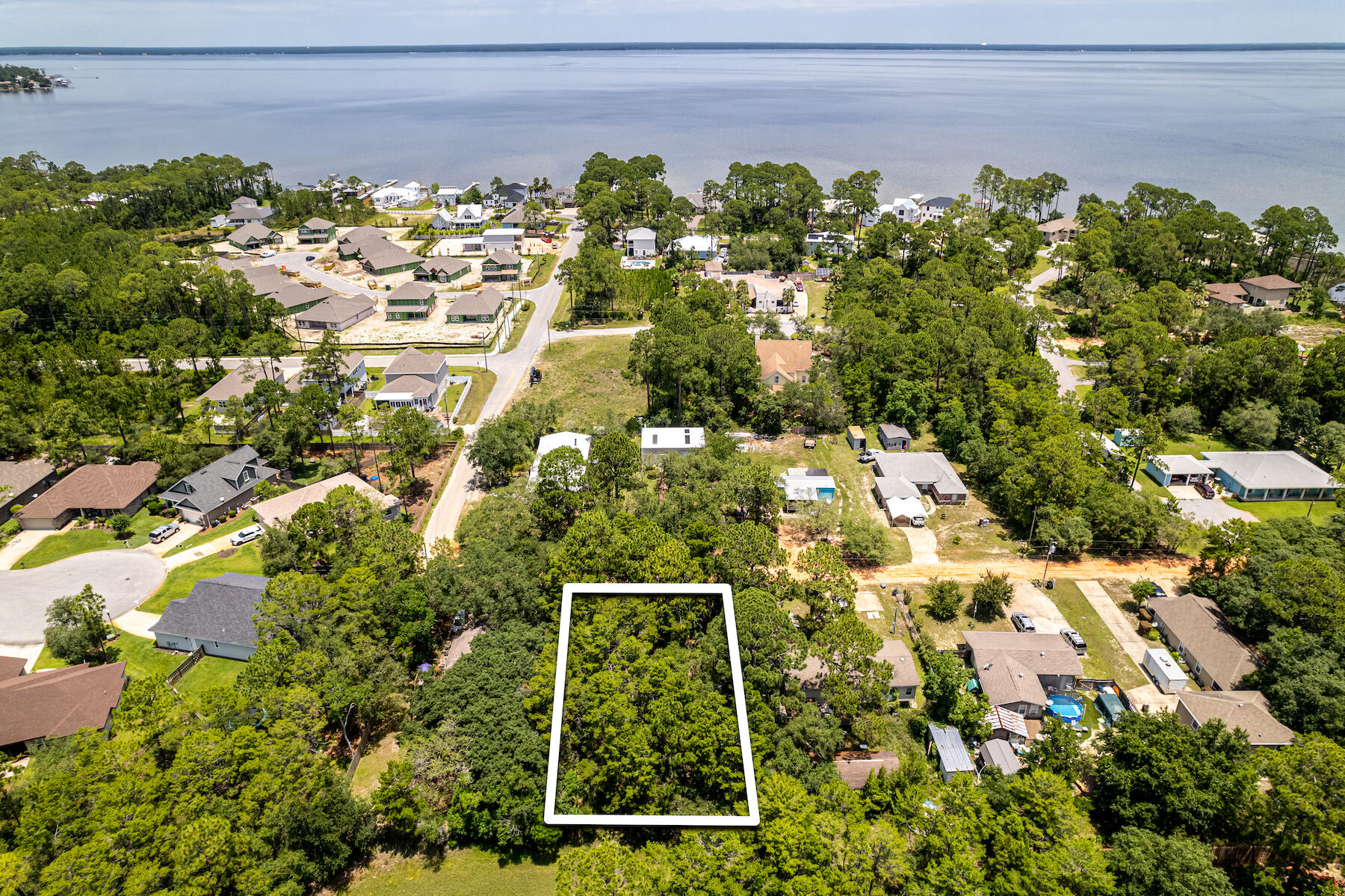 Vacant, 0.25 acre residential lot in the Mack Bayou area (bay side of SRB). Private and quiet with very little traffic! Near Grand Blvd shopping + restaurants! Survey and grant of easement included. No wetlands, HOA, or restrictions on this piece of property. This means you can maximize usage of the lot when building. Lot can easily fit a house plus additional dwelling unit up to 400 sq. ft. (per Walton County Building Codes) with a pool and outdoor oasis.Currently, lot sits on a dirt road but Walton County is in the process of taking it over then road developer will be paving and maintaining the road for county and residents.