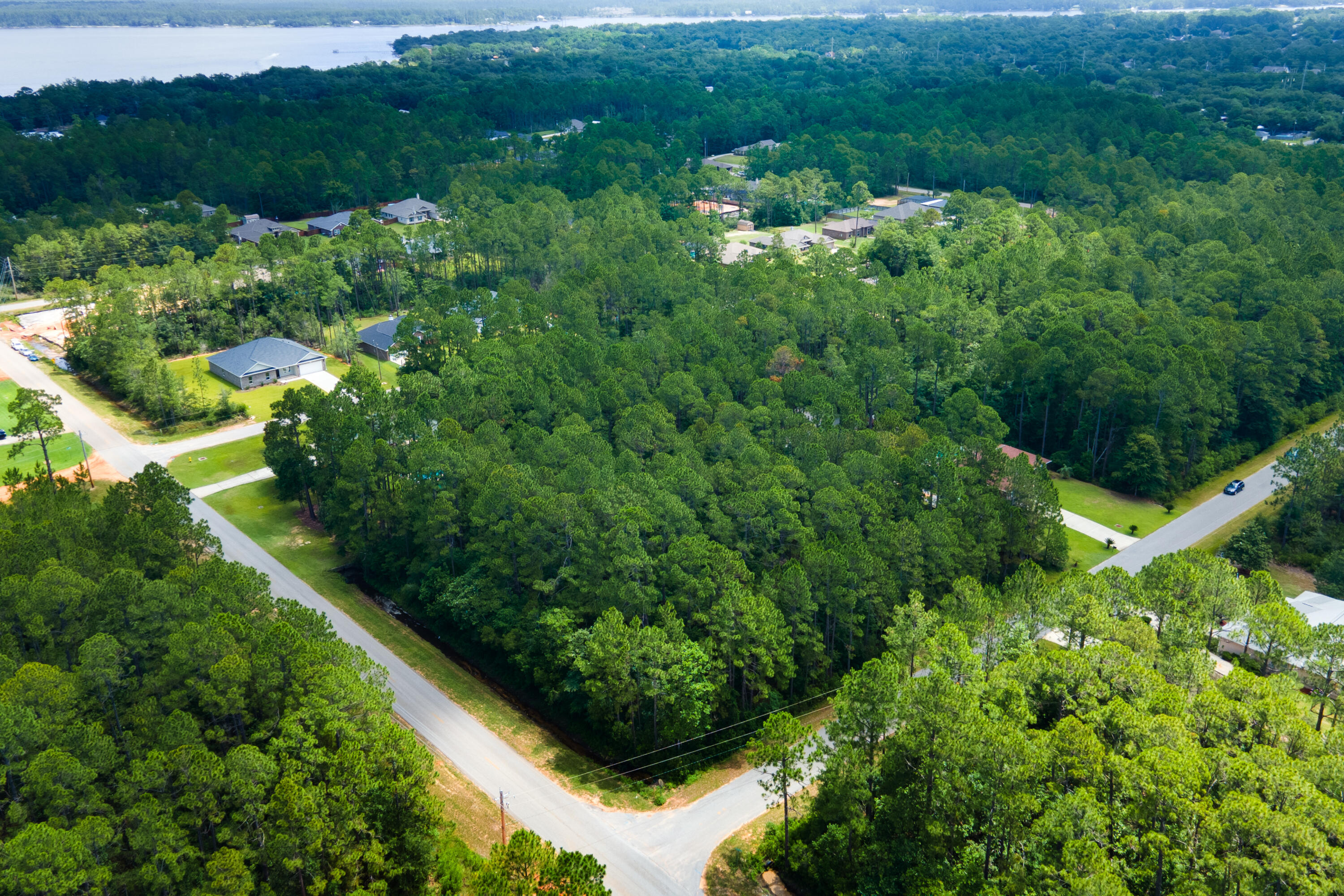 $15k PRICE REDUCTION! Seller offering $5,000 towards closing to offset expenses. Build your dream home in a highly coveted community -- Holley by the Sea -- an incredible experience, especially with the natural beauty and amenities available! The .86-acre wooded lot gives you the flexibility to design a home that fits your vision. Plus, the community's private boat launch, dock, and proximity to nature offer the ideal setting for a relaxed, coastal lifestyle.. This property is situated on a highly sought after corner lot, providing easy access to East Bay Blvd and Hwy 98, ensuring convenient travel to nearby attractions. As a resident of Holley by the Sea, you'll have access to exceptional amenities, including: Private Boat Launch and Dock with direct access to East Bay for boating and fishing enthusiasts. Recreation Center features a fitness center, event rooms, and programs for youth and childcare. Sports Facilities: clay tennis courts, basketball courts, and a walking trail. Two swimming pools (indoor & outdoor) and a private beach house meeting center. Additional Amenities: Fishing pier, RV campsites, picnic shelters, and a pavilion/gazebo.
The community is known for its natural environment, featuring large home sites along with extensive woodland preserves of scented pine, oak, and magnolia trees.
NOTE: Two consecutive wetland studies (2021 & 2023) show that the wetland is decreasing and the dry land is more than large enough for a dream home build, as verified by the available survey that was completed in 2023.
Seems like a perfect place to create a personalized coastal retreat! Contact your agent now or give Jim a call!