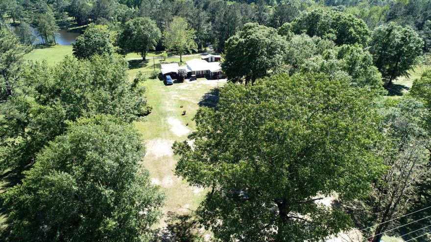 Great 3.27 acre property located North of Laurel Hill! If you like the feeling of country living then this home is for you. This home has a lot to offer and then some. The house itself features a metal roof, wood flooring throughout most of the home, high-end insulation in the ceiling, a large Florida Room, and a former carport converted into a den with a half bath. But that is just the start, as the property just keeps giving! The home has a newer carport cover, a fully powered workshop, as well as a second smaller workshop attached to the small barn! The house sits far back on the property away from the road and surrounded by various fig trees, blueberry bushes, and a few others that produce very well every year.