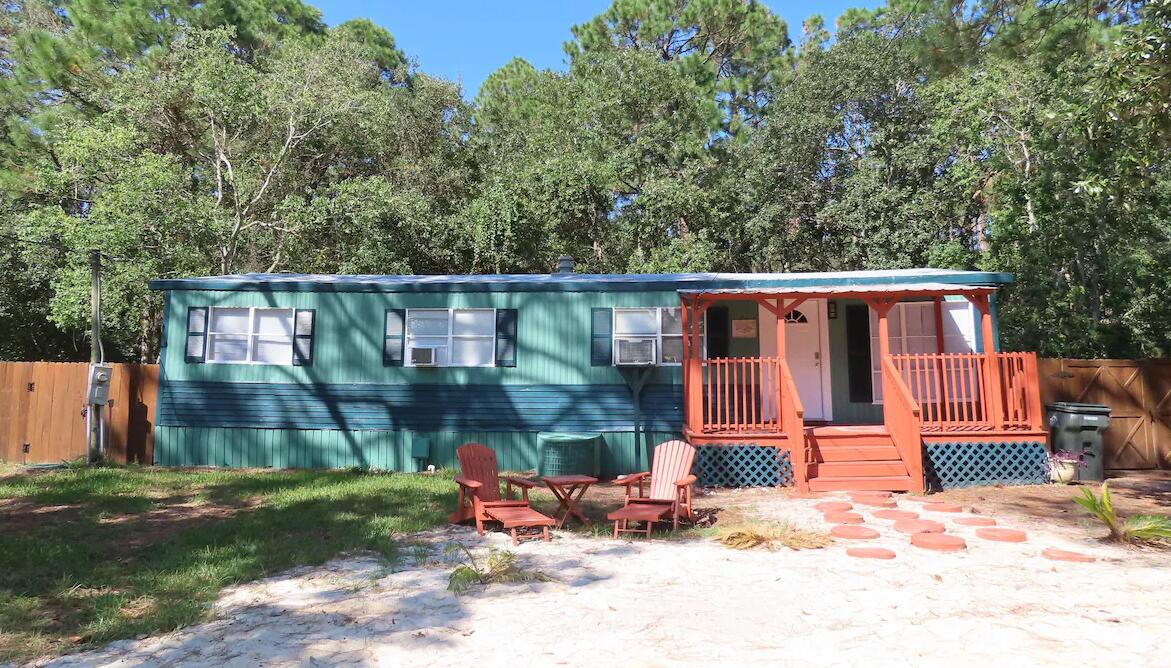 INVESTOR SPEACIAL! Great opportunity for a rental property that sleeps 10 & minutes from Navarre Beach. Property has been an AIRBNB and is currently a month to month rental property with a $2800 monthly income. 3 bedroom 2 bath mobile home directly off of Hwy 90 , nestled on a wooded dead end street. The .27 acre lot offers a serene retreat boasting a spacious deck, yard, and firepit for those after beach goings where you just want to grill out , relax around a bonfire, and sip on an adult beverage as the kids play games in the yard. Location brings comfort and convenience of shopping, entertainment, night life, beach access, dining, fishing, water sports within minutes from the property. 2020 upgrades include: both bathrooms, carpet, vinyl flooring, paint, deck, a tankless water heat Flood Zone X and Zoned RM1