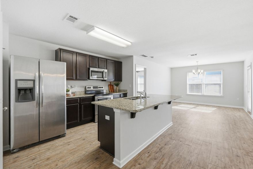 Freshly painted and move-in ready, this beautifully maintained home is located in the desirable Redstone Commons community, featuring a neighborhood pool for residents to enjoy. The popular Aria one-story floor plan offers 3 bedrooms, 2 bathrooms, a covered back porch, and a two-car garage, designed for both comfort and functionality. The open-concept kitchen showcases a center island, stainless steel appliances, and granite countertops, flowing seamlessly into the spacious great room with easy access to the covered porch. Step outside to a fully fenced backyard with a privacy fence, perfect for pets, play, or relaxing in your own outdoor retreat.The private primary suite features a generous walk-in closet and a spa-inspired bath with a separate shower, and a large soaking tub. Conveniently located close to schools and offering an easy commute to area military bases, this home combines comfort, location, and lifestyle in one inviting package.