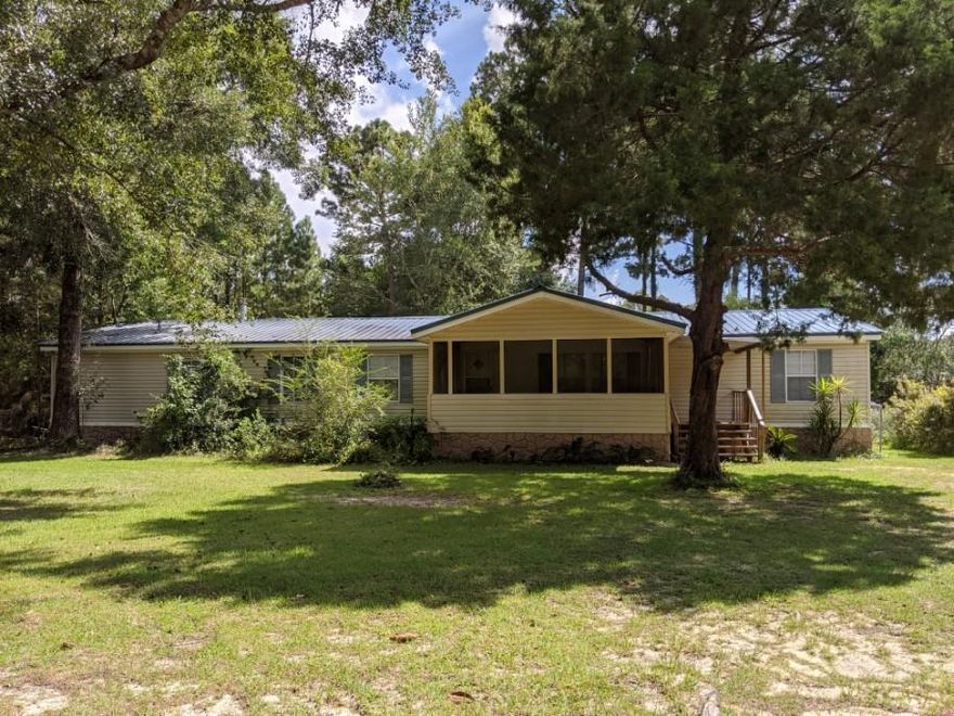 Deal fell through on this double-wide permanently set property.   There's a recent multi-purpose addition that would make a great place to home-school, rec room or even extended guest area.  It has it's own bath & entrance.  The master bedroom has a separate sitting area that would also work as a home office or nursery.  It has a privacy door from the bedroom.  Plus there are three other roomy bedrooms.  There are two separate living areas.  The family room has a fireplace and the dining room will accommodate most gatherings.  It has good closet space and a separate laundry area.  Extend your living on the enclosed front porch.  It's suitable for cooking out, lounging or entertaining.  There's a large out building plus no neighbors to the rear of the property. Buyers to verify measurements