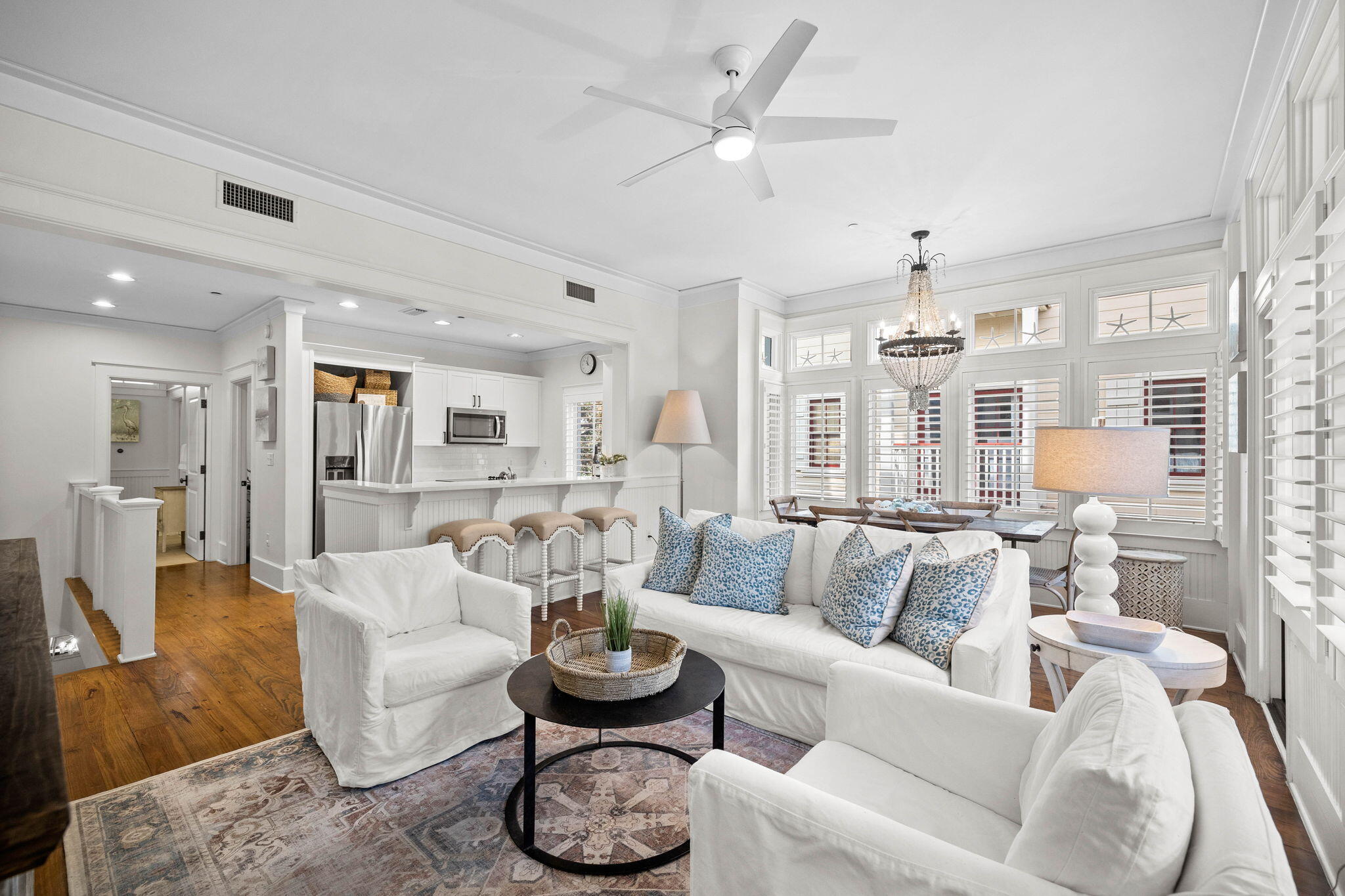 Experience the epitome of contemporary coastal living in this immaculate townhome in WaterColor's coveted Beach District. Nestled in an ideal location adjacent to the WaterColor Town Center, this exquisitely adorned corner unit offers 1286 square feet of conditioned space plus an additional 300 square feet of covered porch space. Enjoy seamless access to the WaterColor Beach Club and the enchanting emerald-green waters of the Gulf of Mexico. The second floor living and dining space, adorned in soothing shades of white and blue, provides a tranquil retreat after a day in the sun. Transom windows add natural light to this welcoming and comfortable space with beautiful hardwood floors throughout. Step onto the delightful balcony adjacent to the living room, where ample seating invites